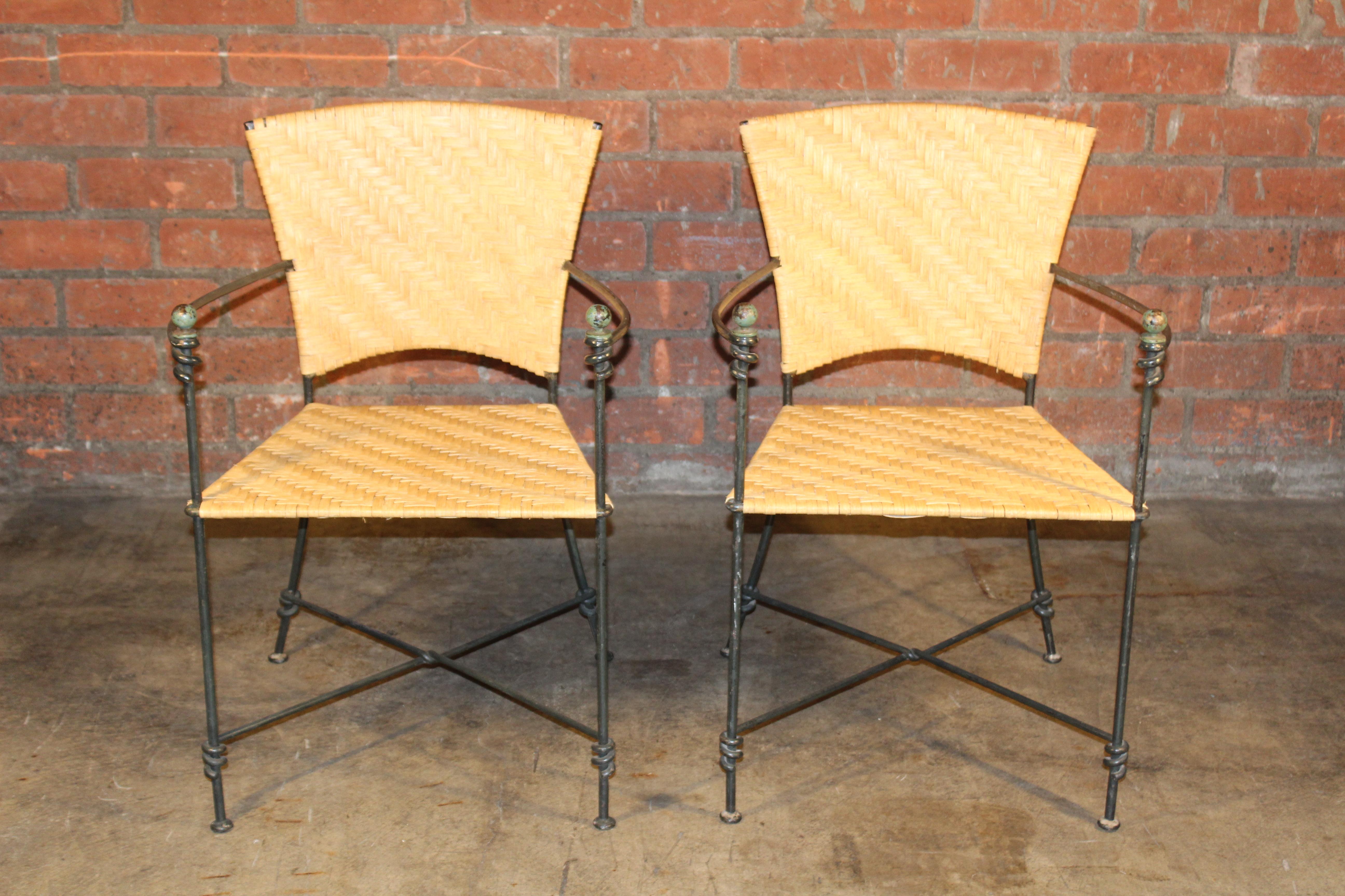 Pair of iron armchairs with new rattan woven seats and backs. In good condition, the iron frames show patina. Sold as a pair.