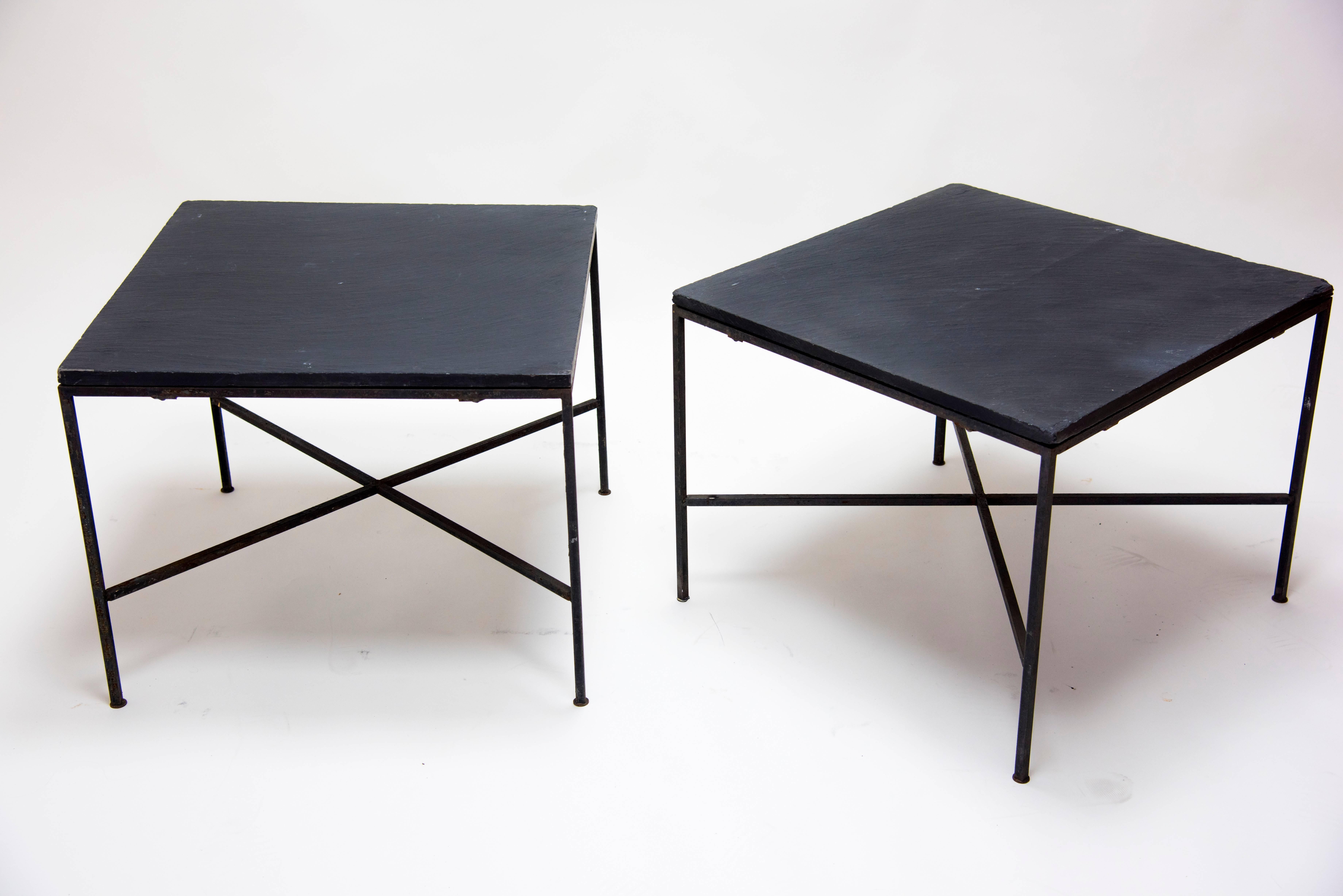 Pair of Mid-Century Modern end tables with clean lined iron base with X-form stretchers and dark slate tops. Appropriate for indoor or outdoor use.