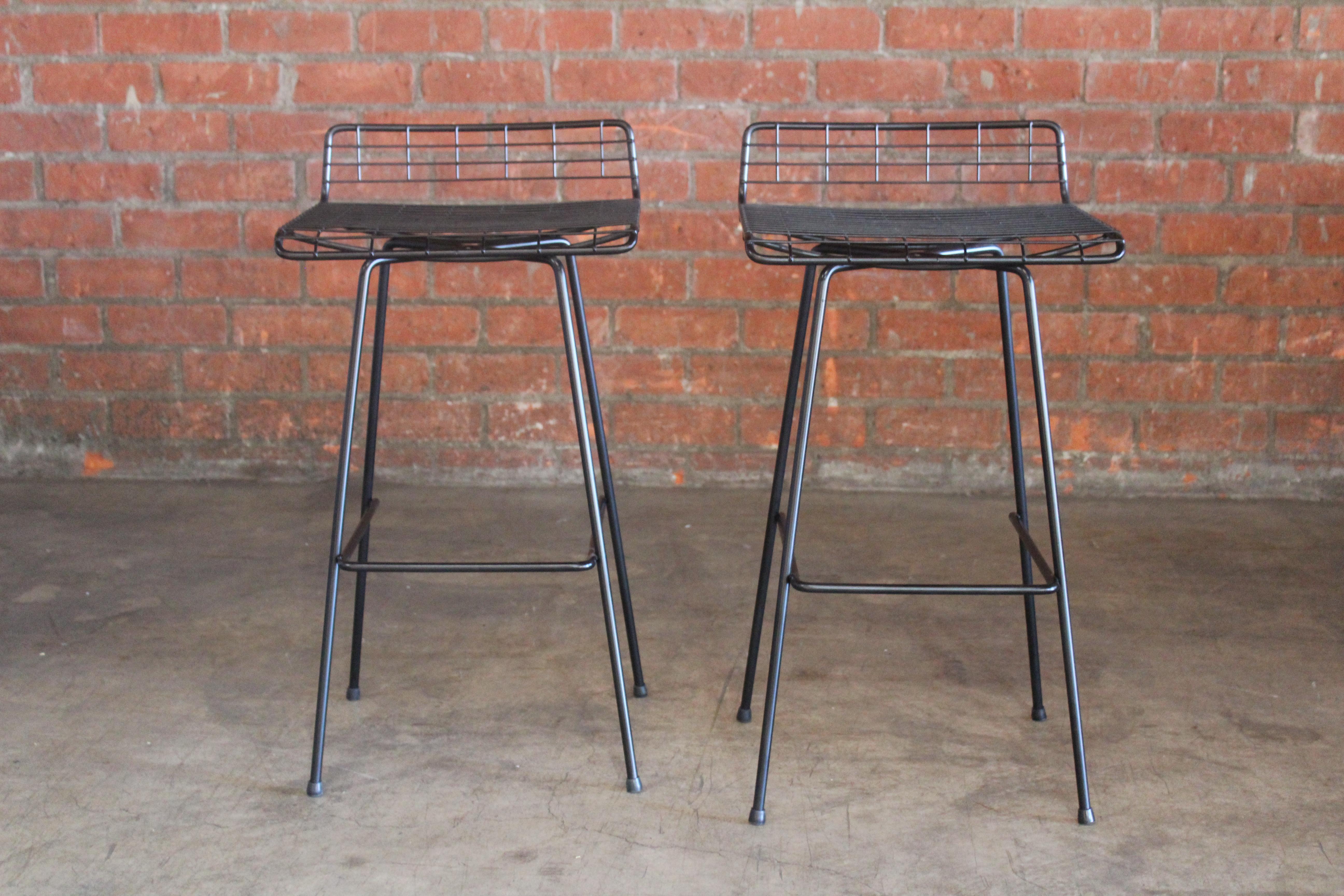 Pair of iron bar stools by John Keal for Pacific Iron, California, 1950s. The pair are in excellent pristine condition. New rubber foot glides. Sold as a pair.