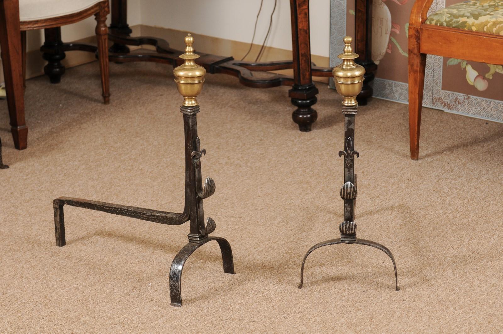 18th century French iron andirons featuring fleur de lis decoration and brass finials.