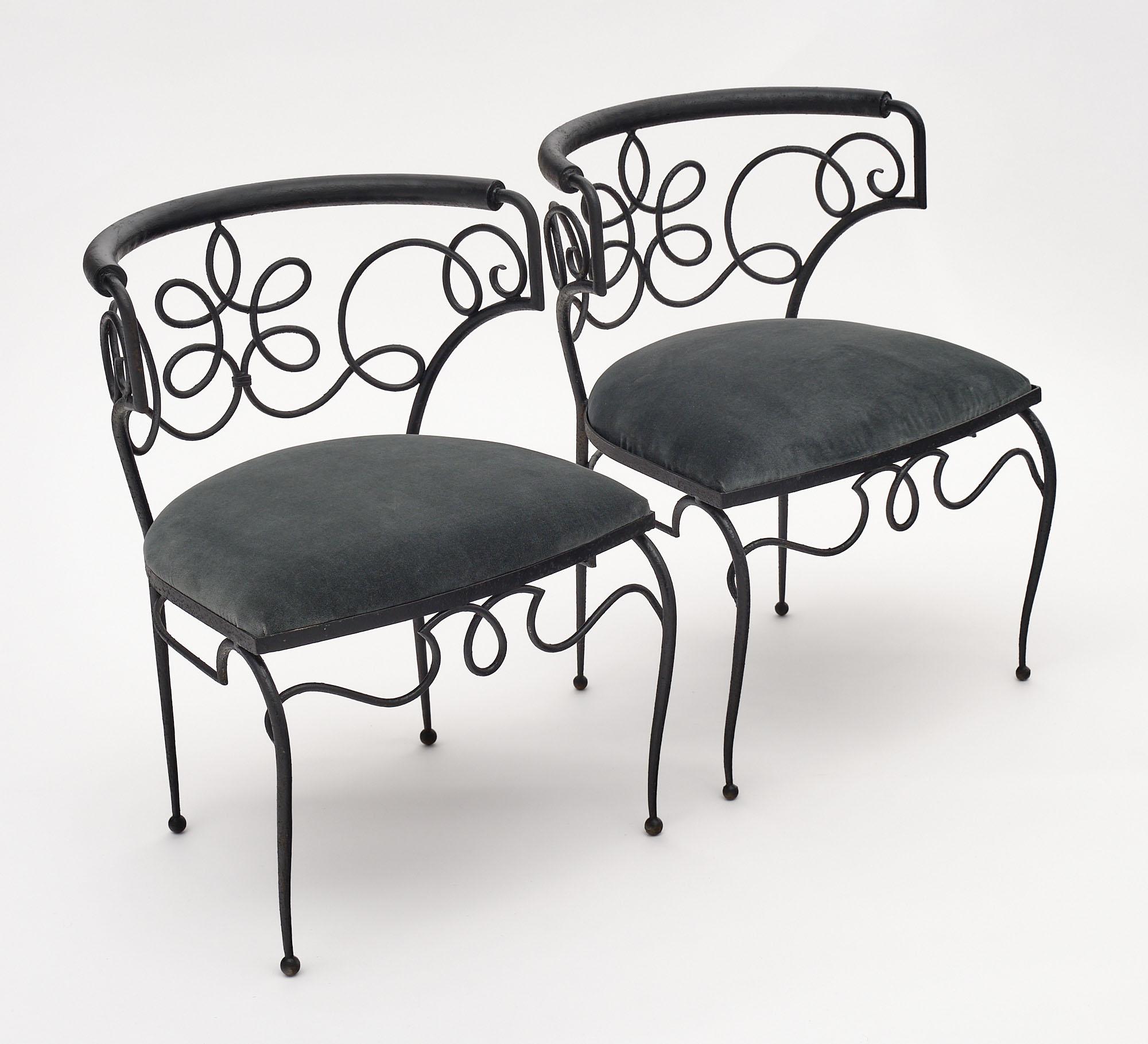 A pair of armchairs made of wrought iron by René Drouet. They have been newly upholstered in a gray velvet blend.