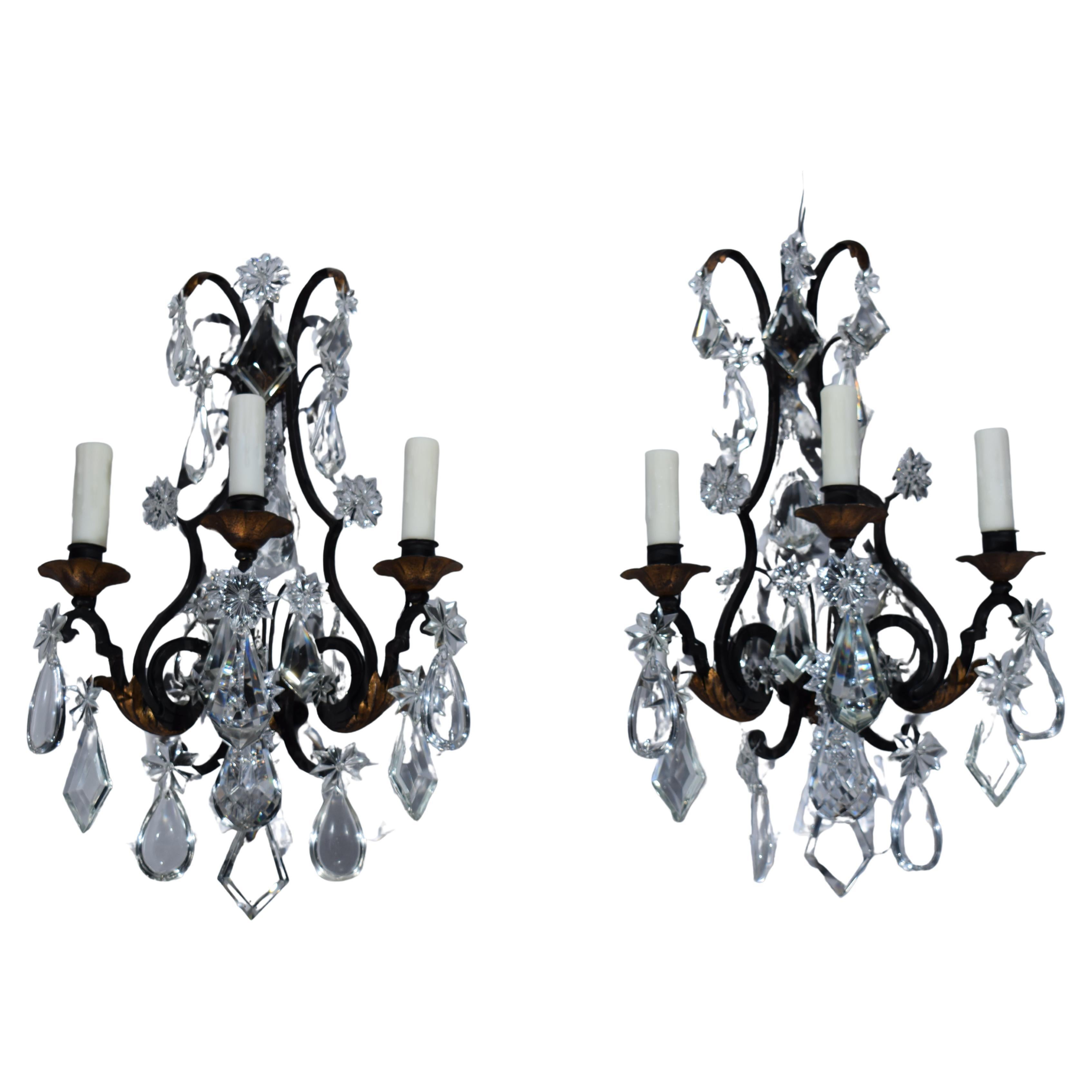 Paire d'appliques murales en fer et cristal de style Louis XV. en vente