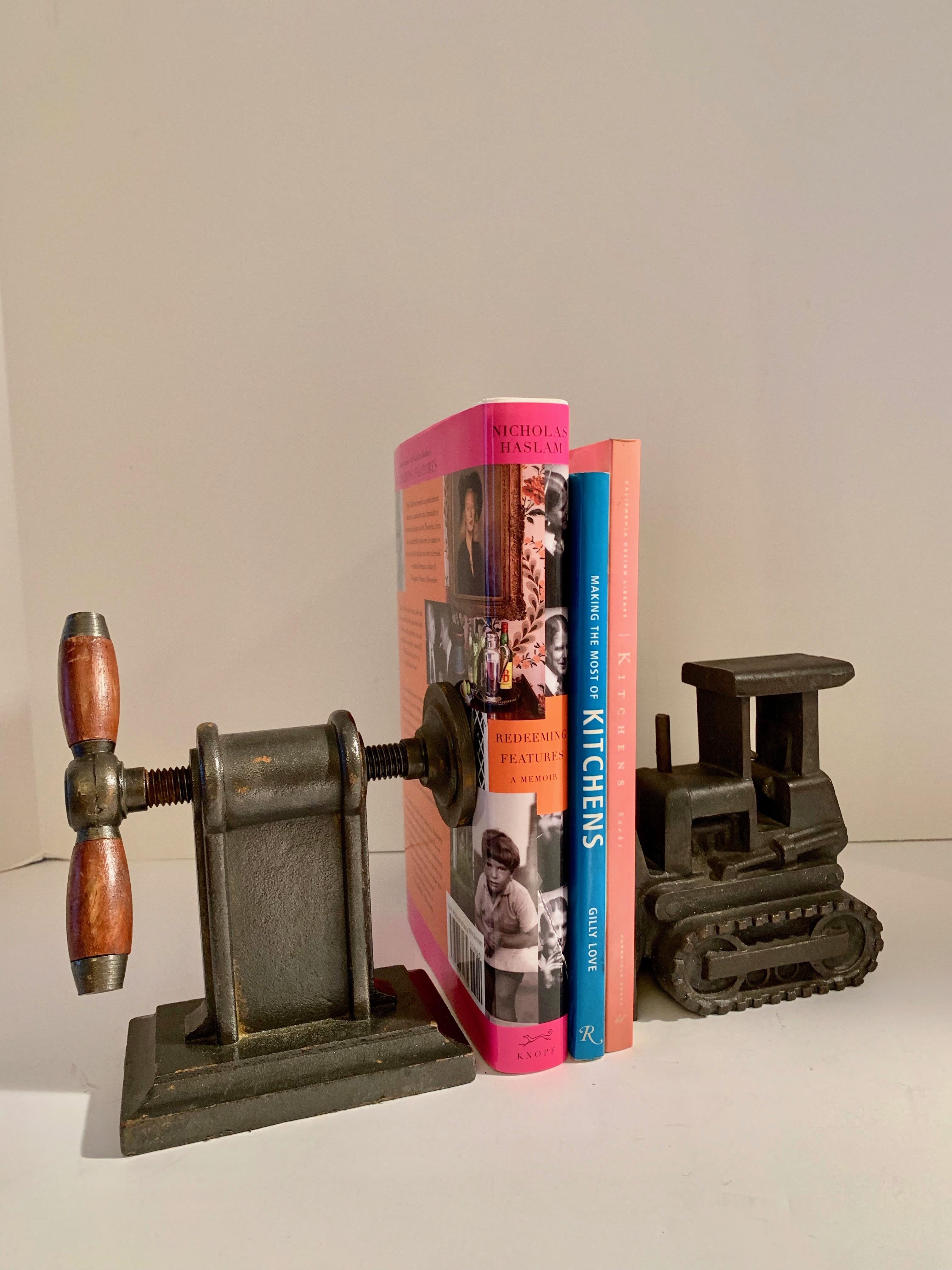 Pair of iron industrial bookends - both pieces heavy iron... one a bull dozer, the other a wood handle crank. Perfectly suited for the kids room, den or office.