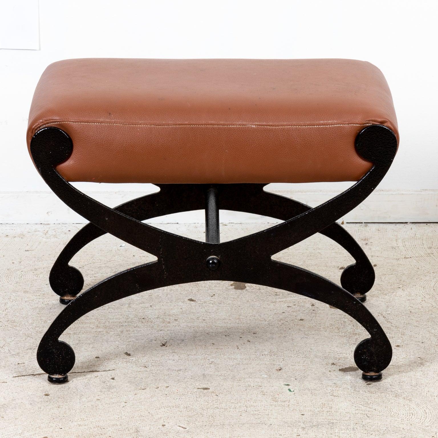 Pair of Iron x-base curule shaped stools with leather upholstered seats. Please note of wear consistent with age including finish loss, patina, and minor oxidation to the metal. The leather also shows staining and dark spots due to daily use.
   