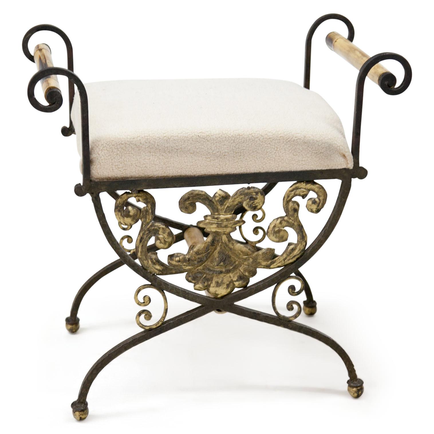 Pair of curule tabourets made of iron with a gold painted leaf-ornaments and C-buckles. The armrests are out of bamboo.