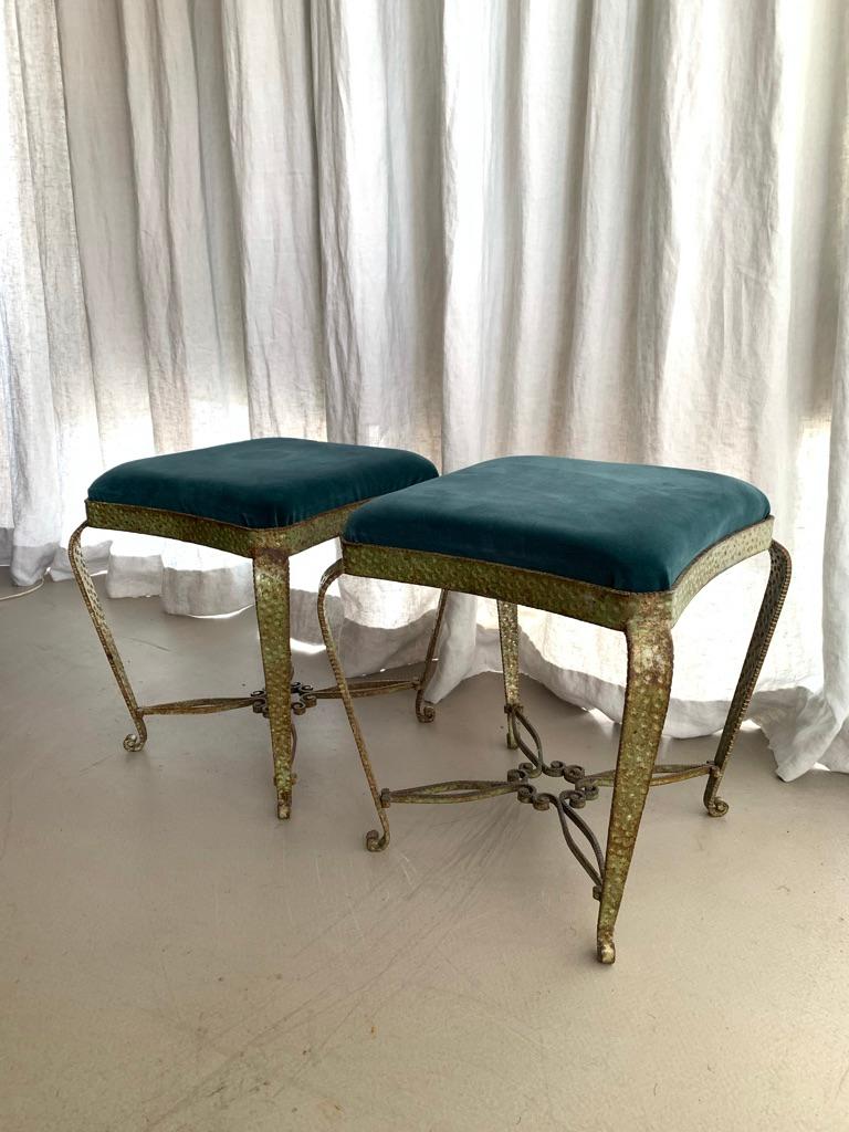 Pair of vintage Italian stools with a patinated bronze green, called verdigris finish on wrought and embossed iron. The stools are upholstered in an emerald green velvet, which can easily be changed if one wishes to do so. 