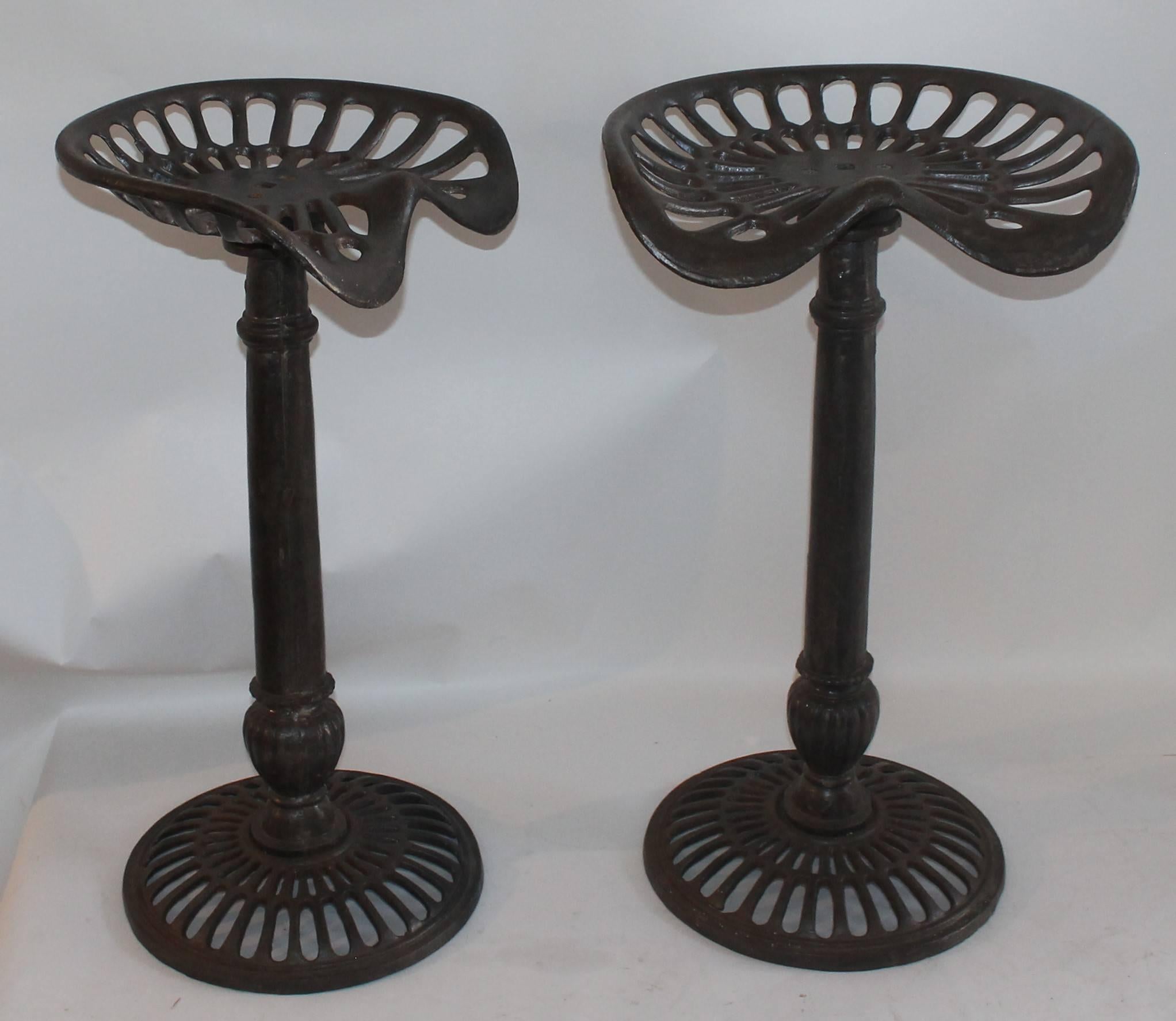 This pair of iron base and iron tractor seat bar stools are in good and sturdy condition.