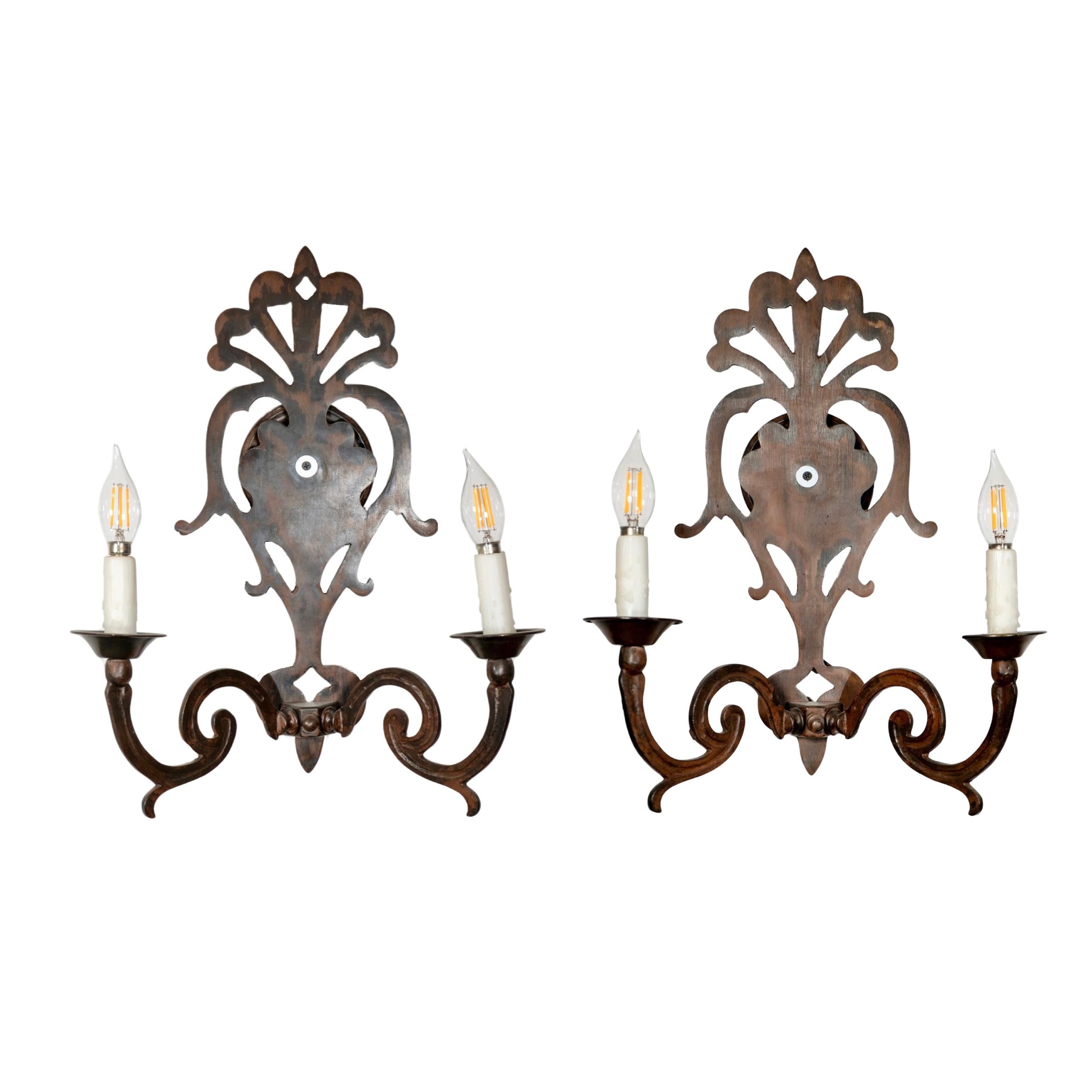 Add a touch of classic elegance to your home with this pair of iron wall sconces. Made in France during the mid-century, these pre-wired sconces are perfect for illuminating any room. Sold as a pair, they are a timeless addition to any decor.