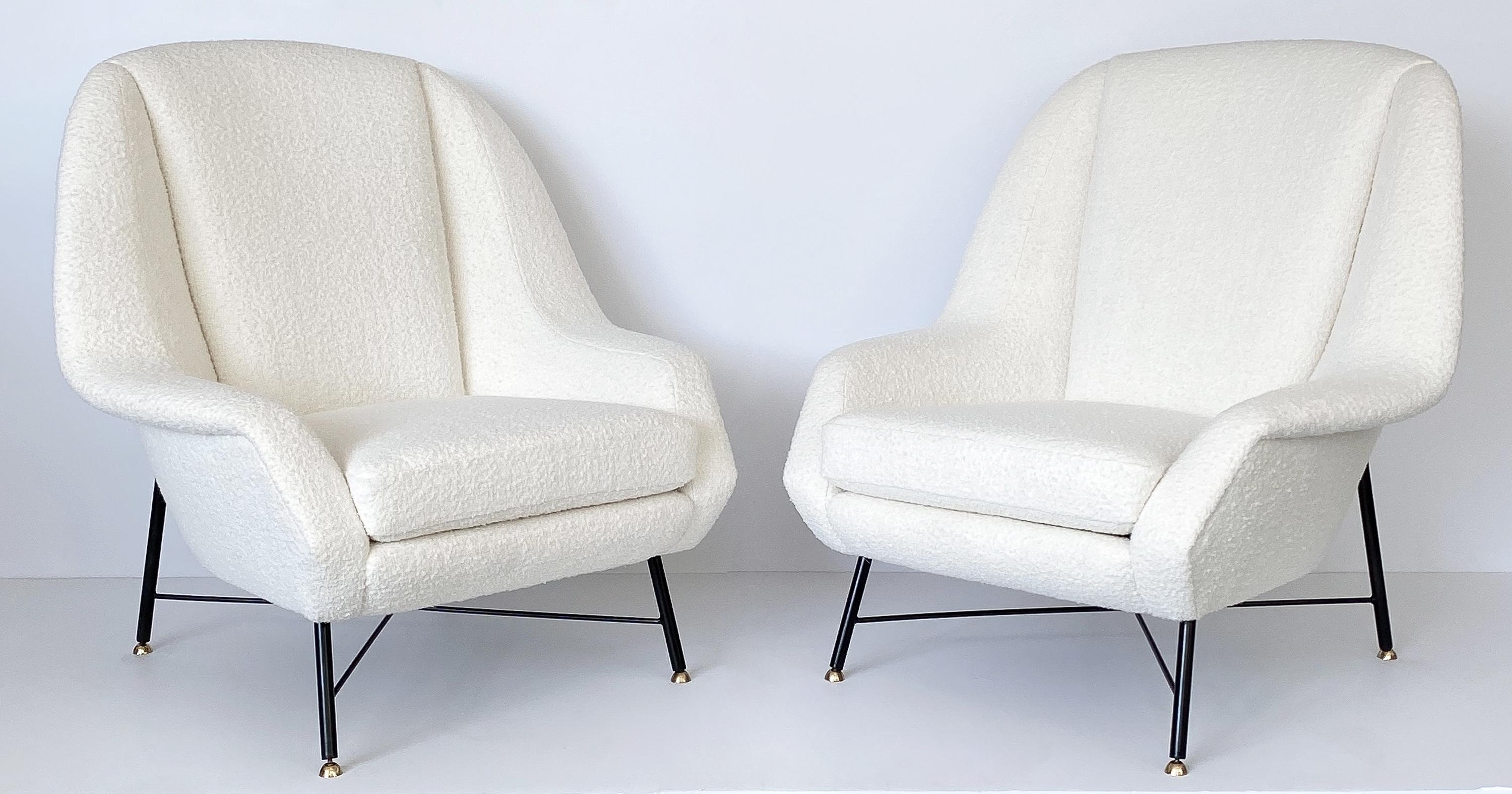 An incredible stunning pair of Italian lounge chairs by ISA Bergamo, circa 1950s. Newly upholstered in a warm white heavily textured Italian wool bouclé. New foam throughout. Tight upholstered back with loose seat cushion. Black enameled metal base