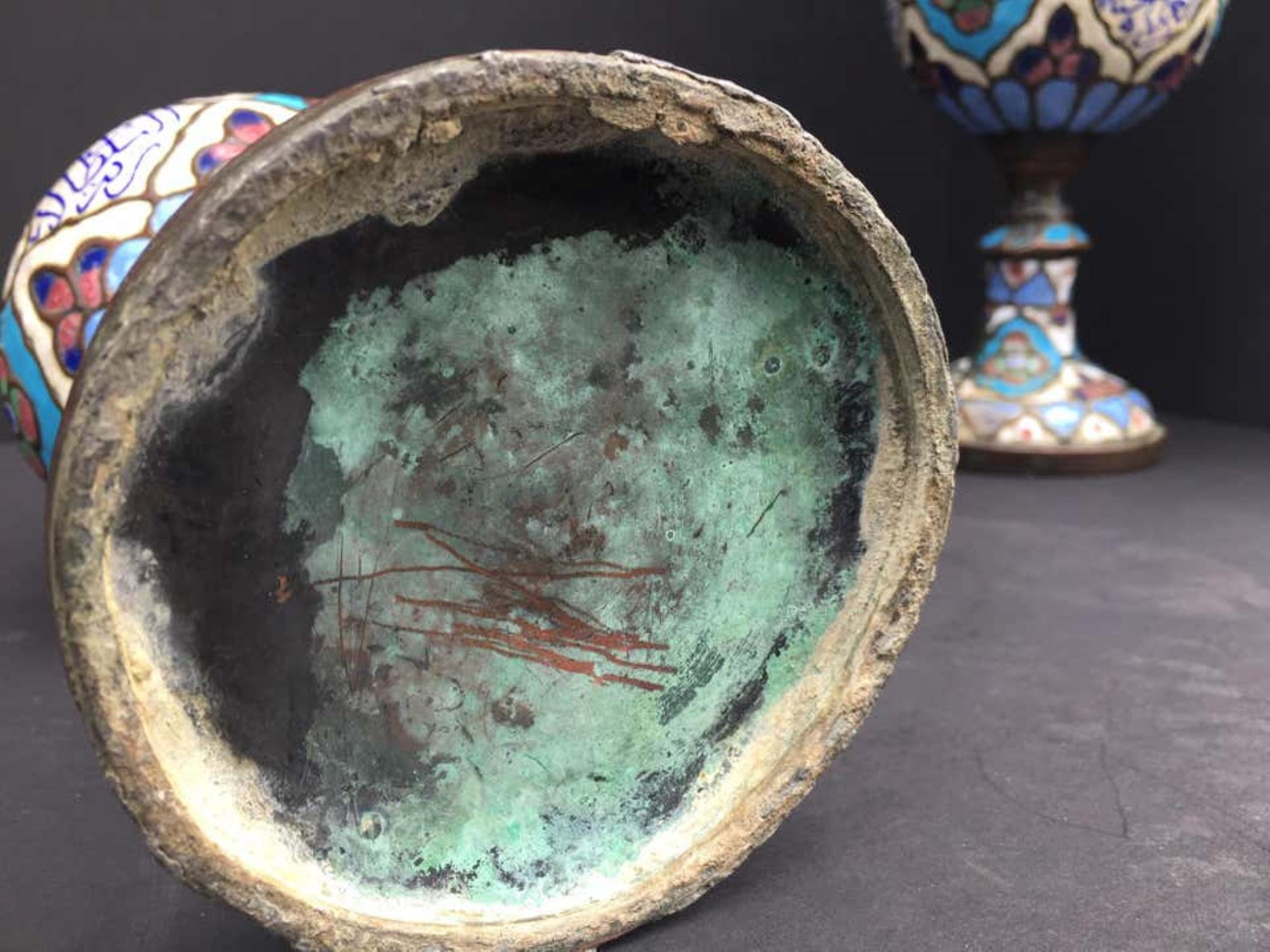 Dies ist ein außergewöhnliches und historisches Paar emaillierter Metallgefäße oder Urnen aus Damaskus. Diese Kunstgegenstände weisen Spuren von rauem Gebrauch und Handhabung im Laufe der Jahrhunderte auf. Obwohl es fast unmöglich ist, das Alter von