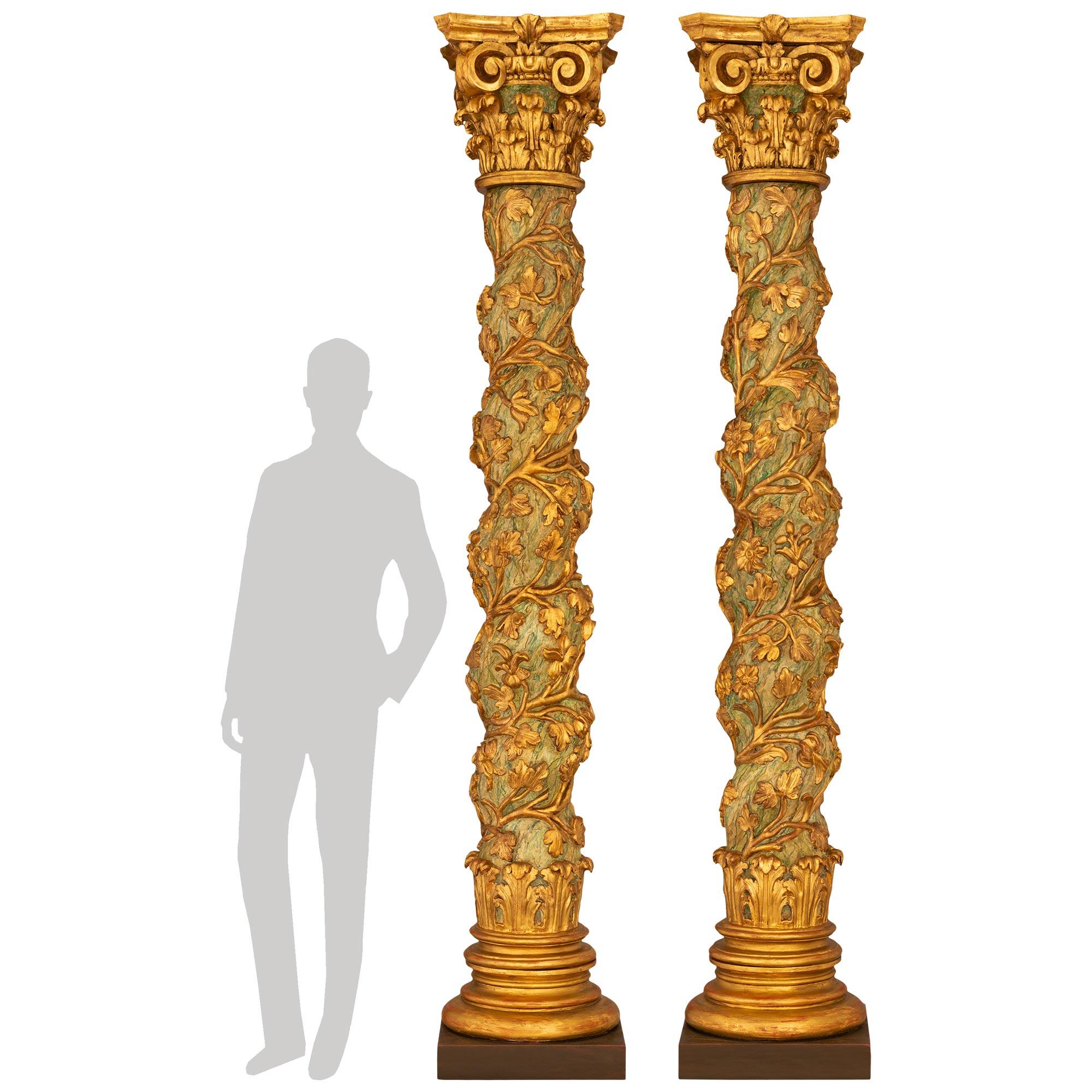 Magnifique paire de colonnes italiennes du XVIIe siècle de style baroque, patinées et en bois doré, vers 1670. Chaque colonne tournée en spirale est soutenue par une plinthe carrée en bois patiné, sous un double socle en bois doré tacheté et des