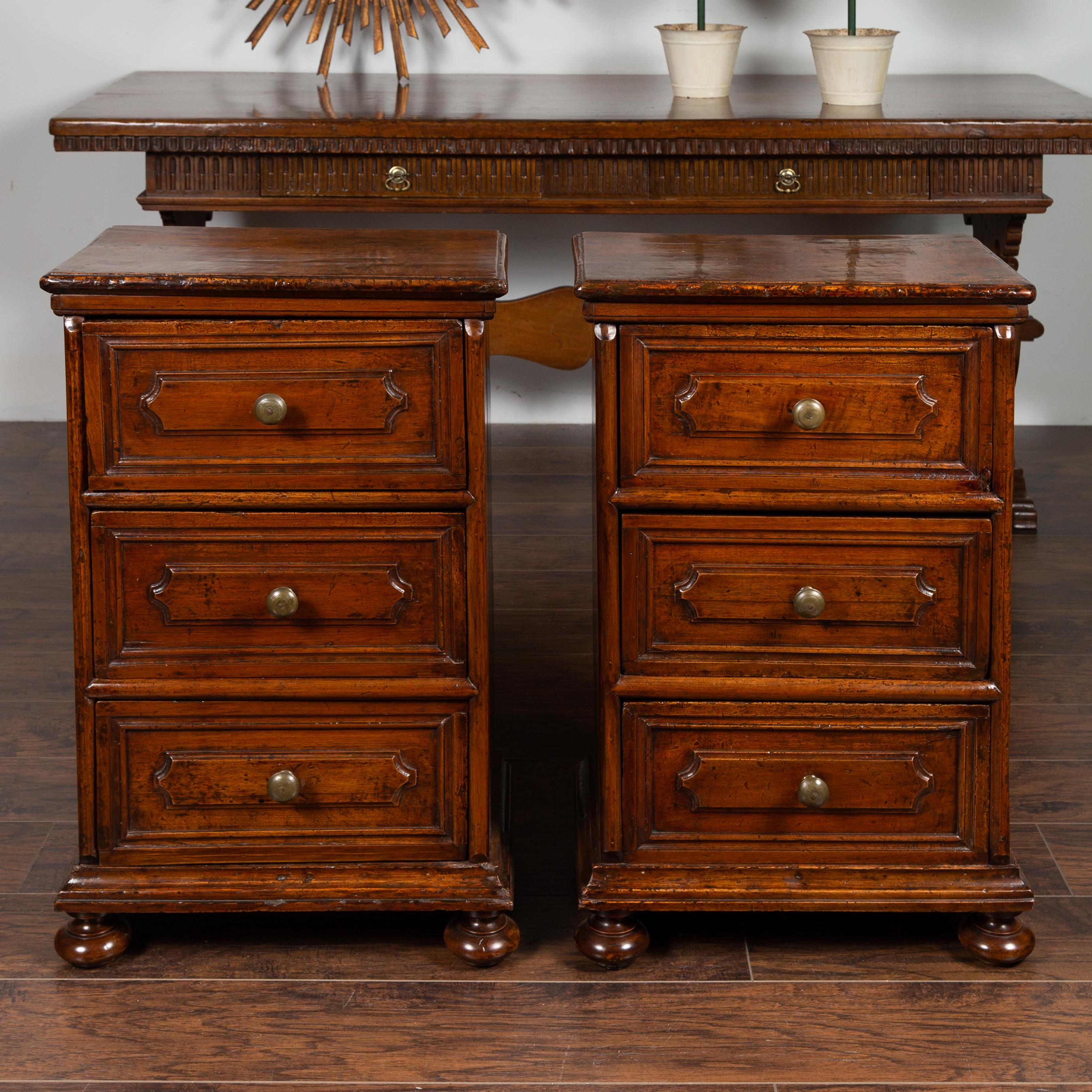 A pair of Italian walnut commodini from the mid-19th century, with three drawers and bun feet. Born in Italy during the third quarter of the 19th century, each of these petite commodes features a rectangular top sitting above three drawers adorned