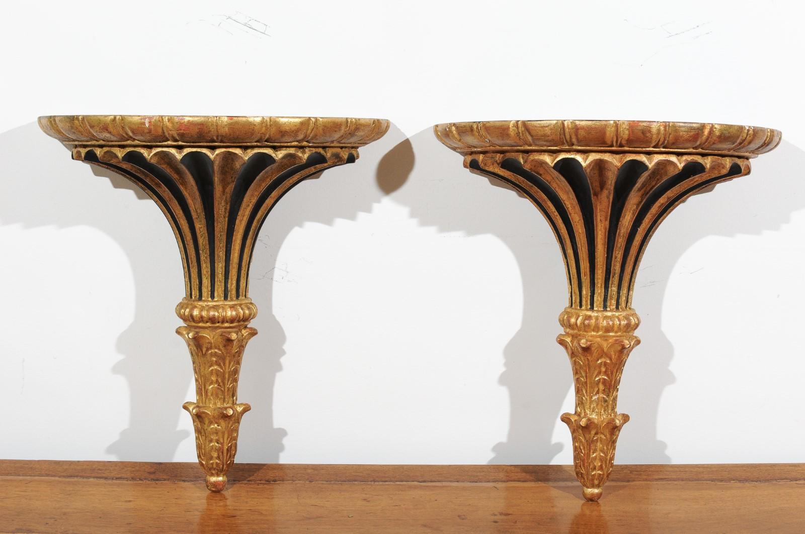 A pair of Italian painted and carved wall brackets from the late 19th century, with black and gold accents. Born in Italy during the third quarter of the 19th century, each of this pair of wall brackets features a flared gilded body presenting a