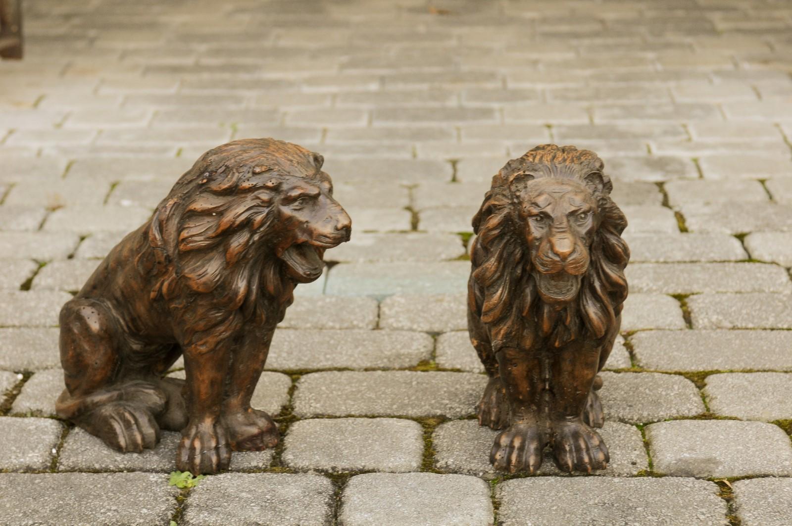 A small pair of Italian walnut hand carved roaring lion sculptures from the late 19th century, with dark patina. Born in Italy during the later years of the 19th century, each of this exquisite pair of sculptures features petite roaring lions,
