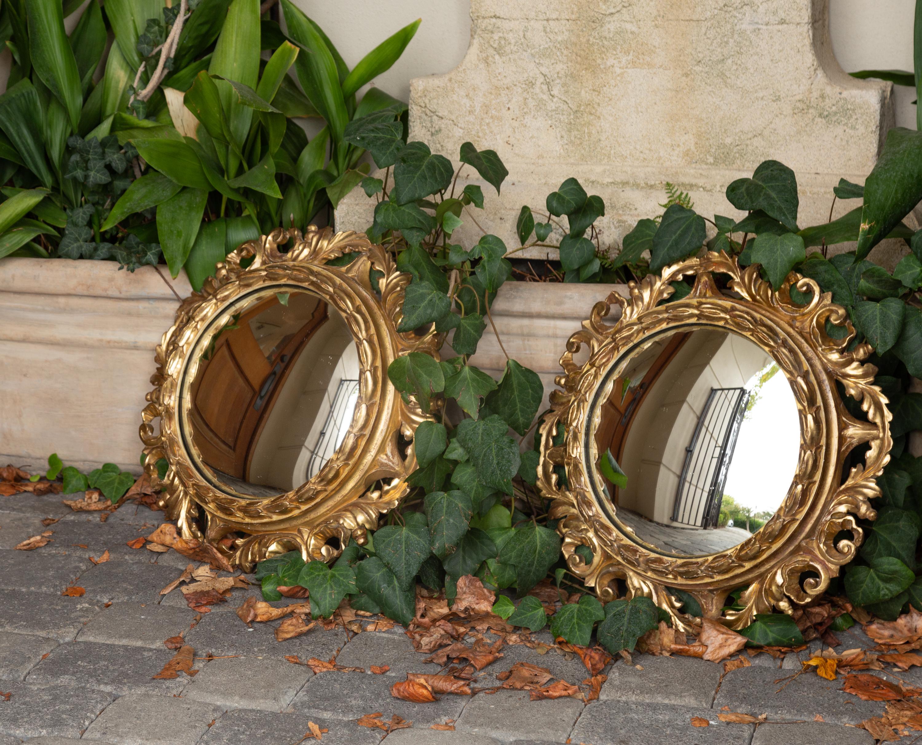 Ein Paar italienische runde, konvexe Spiegel aus vergoldetem Holz aus dem späten 19. Jahrhundert mit Blattwerkmotiven. Die beiden Wandspiegel wurden im letzten Viertel des 19. Jahrhunderts in Italien hergestellt und haben jeweils einen schönen