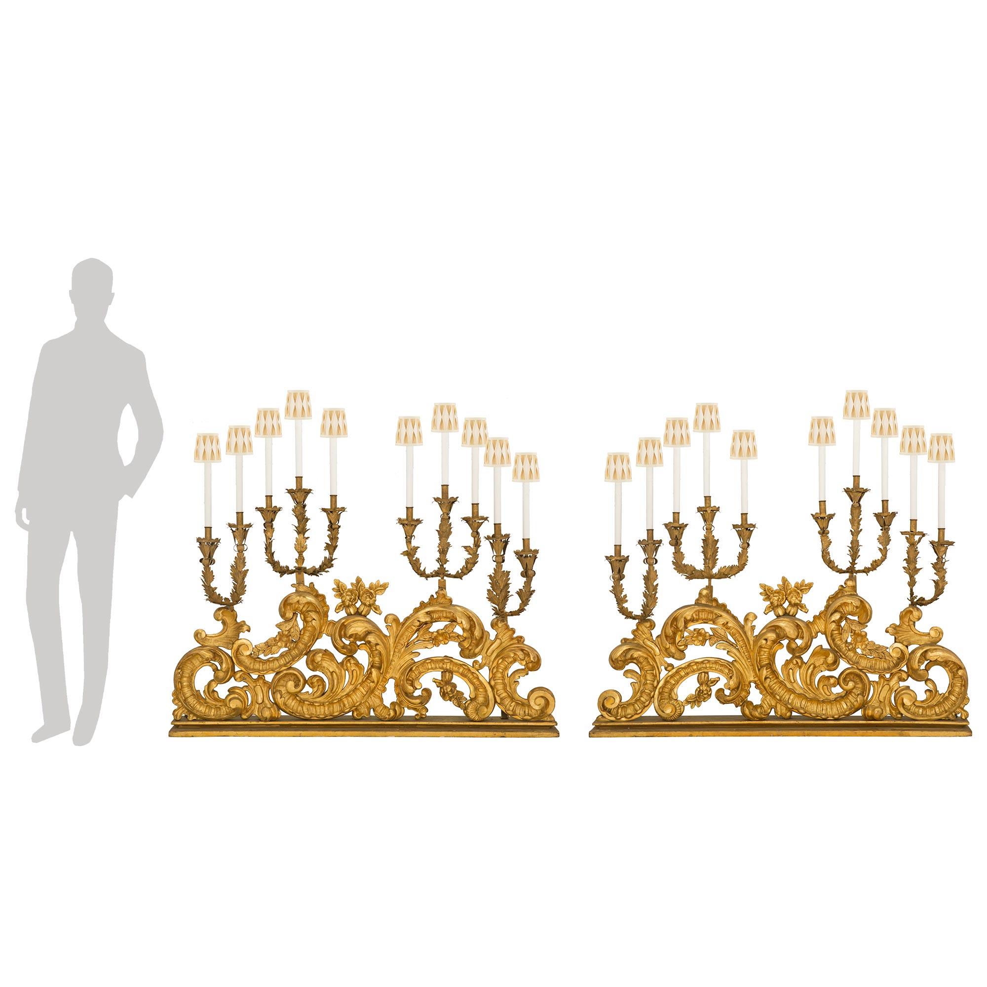 Una coppia spettacolare e di grandi dimensioni di lampade a candelabro elettrificate del periodo barocco italiano del XVIII secolo. Ogni impressionante candelabro a dieci luci è sollevato da una base rettangolare screziata da cui sembrano spuntare