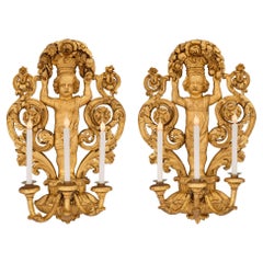 Coppia di lampade a tre bracci in legno dorato del periodo barocco del XVIII secolo