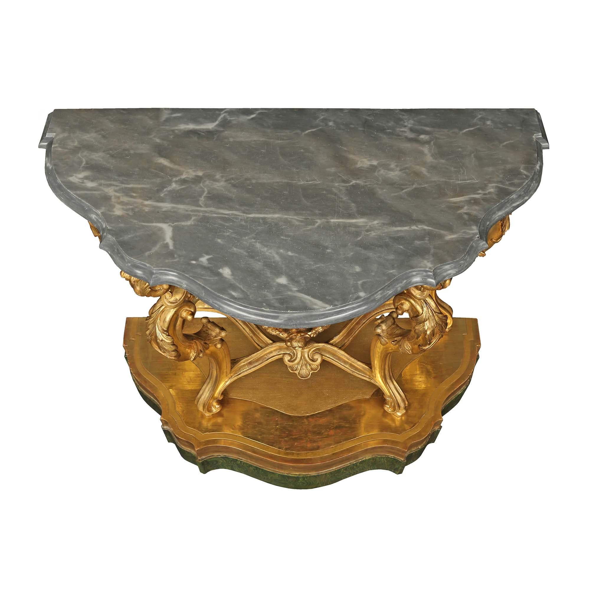 A sensational and high quality pair of Italian 18th century Baroque st. consoles from the Lombardi region. The consoles are raised by scalloped shaped faux painted malachite and giltwood bases with a stunning hammered design. Each display elegant