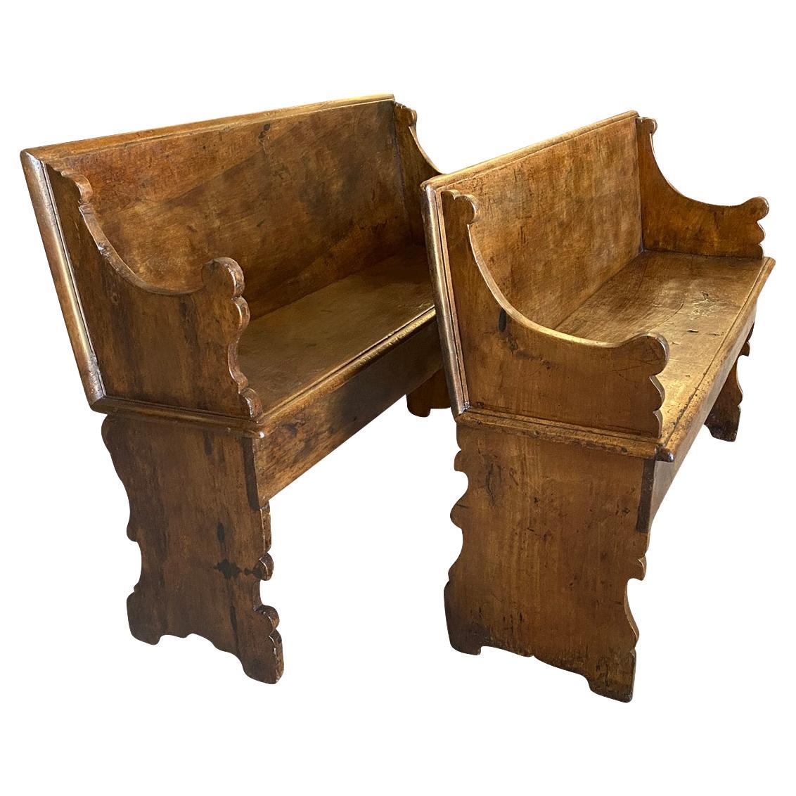 A wonderful pair of 18th century benches from Bologna, Italy. Beautifully constructed from handsome walnut with solid board backs & seats and wonderfully sculpted arms and legs. One bench measures 39