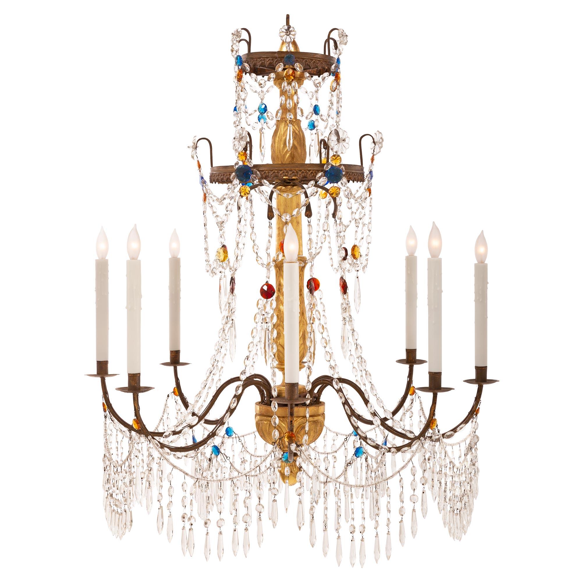 An exceptional pair of Italian 18th century Genovese st. giltwood, pressed metal, glass, and crystal chandeliers. Each eight arm chandelier is centered by a charming bottom foliate finial below most decorative carved acanthus leaf designs. Each