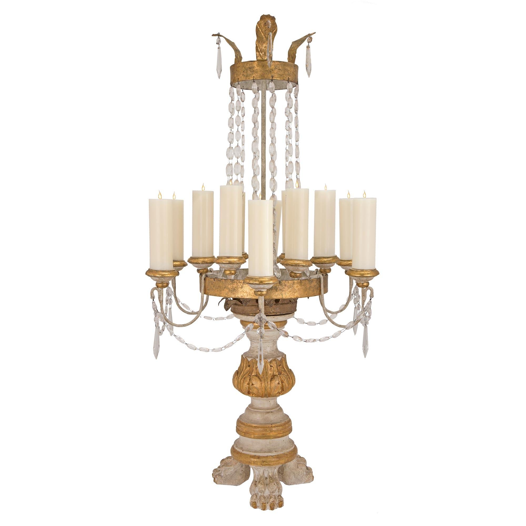 A very unique and large scale pair of Italian 18th century giltwood and gilt metal Tuscan candelabras. Each stunning twelve candle candelabra is raised by patinated paw shaped feet. The central patinated support is adorned with giltwood bands and