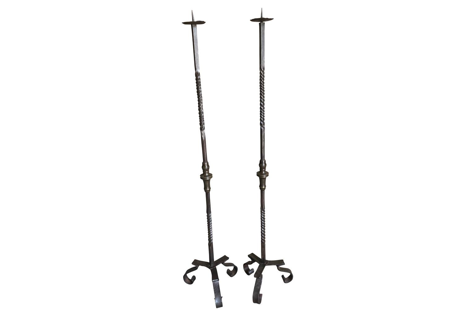 A very handsome pair of later 18th century Torcheres in hand forged iron and bronze. Beautiful patina. Perfect for candles or electrified as floor lamps.