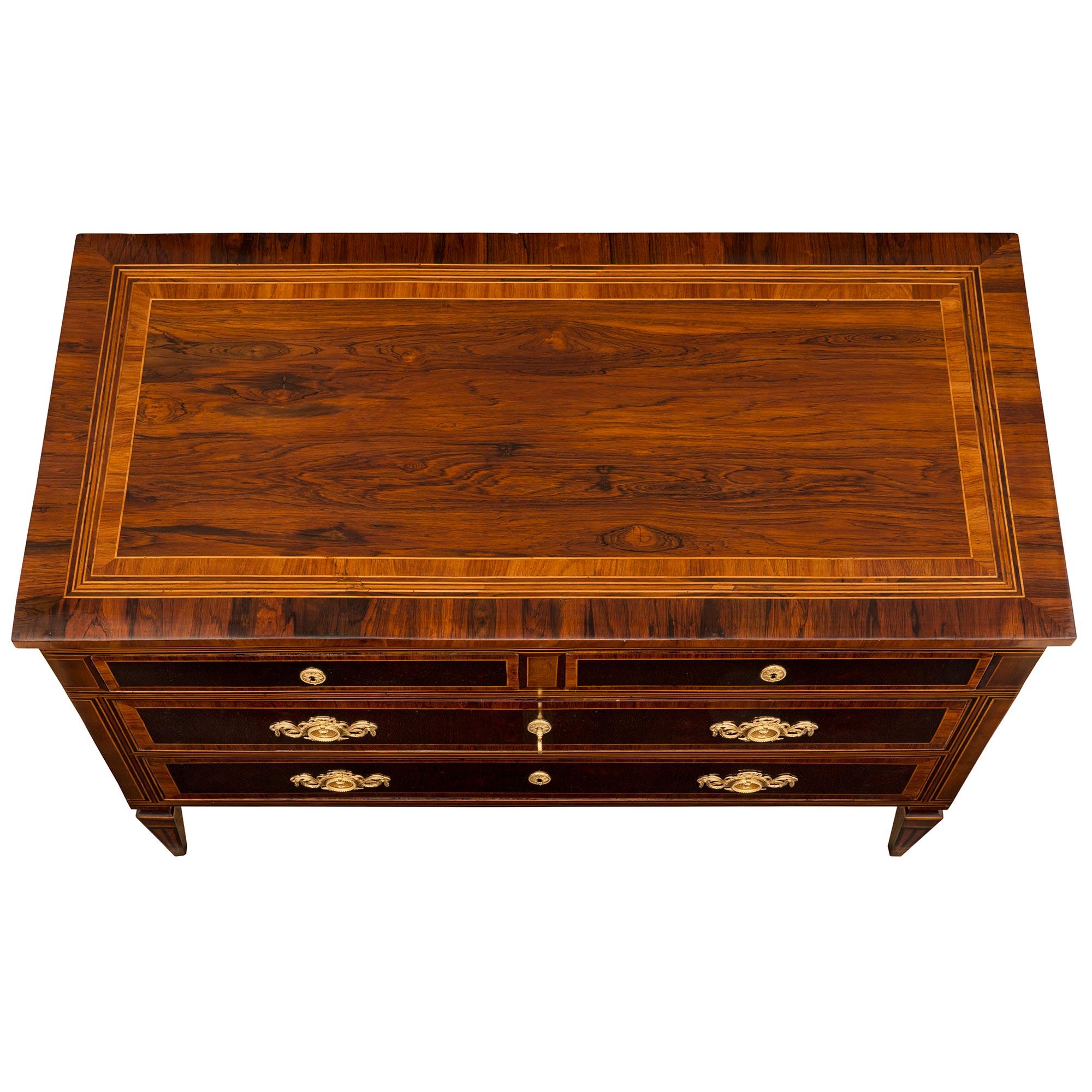 A stunning and most elegant pair of Italian 18th century Louis XVI period rosewood, tulipwood, and ormolu commodes. Each four drawer chest is raised by fine square tapered legs with lovely and most decorative inlaid designs. Above the straight