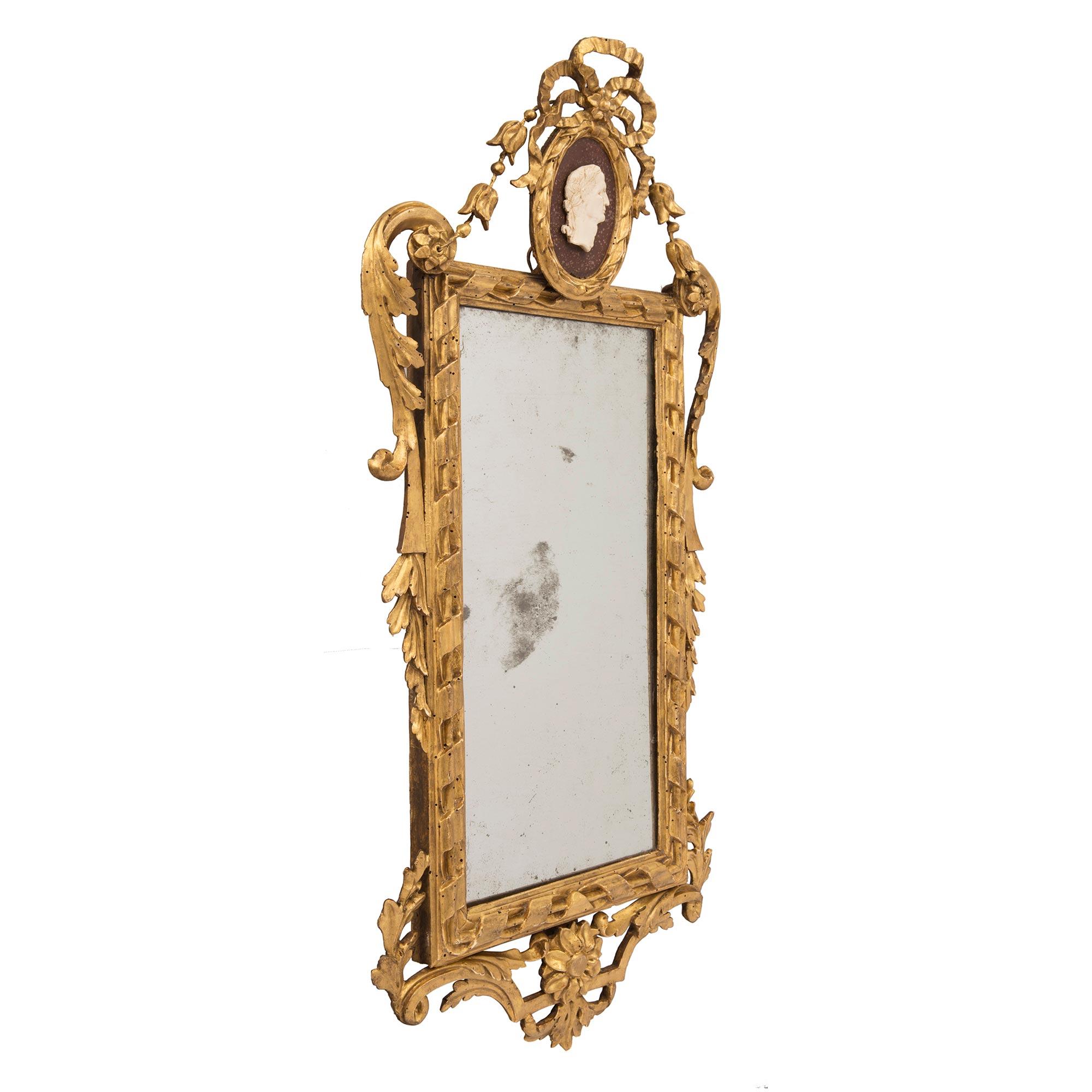 An exceptional true pair of Italian 18th century Louis XVI period giltwood mirrors with faux painted both Porphyry and white Carrara marble. Each elegant mirror retains their original mirror plates framed within a most decorative twisted rope