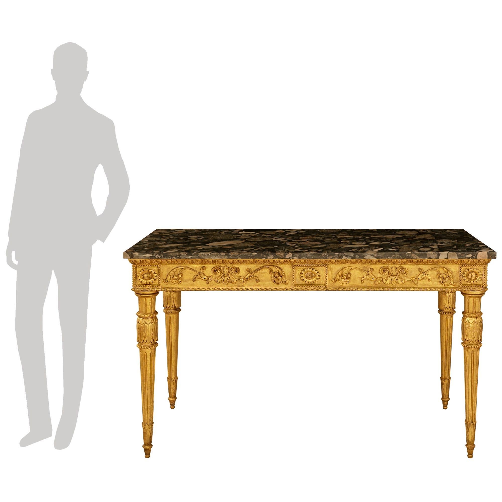 Pareja de consolas italianas del siglo XVIII, estilo Luis XVI, de madera dorada y mármol Breccia, de gran belleza y calidad. Cada consola rectangular independiente, muy decorativa, se eleva sobre elegantes patas acanaladas y decoradas con follaje,