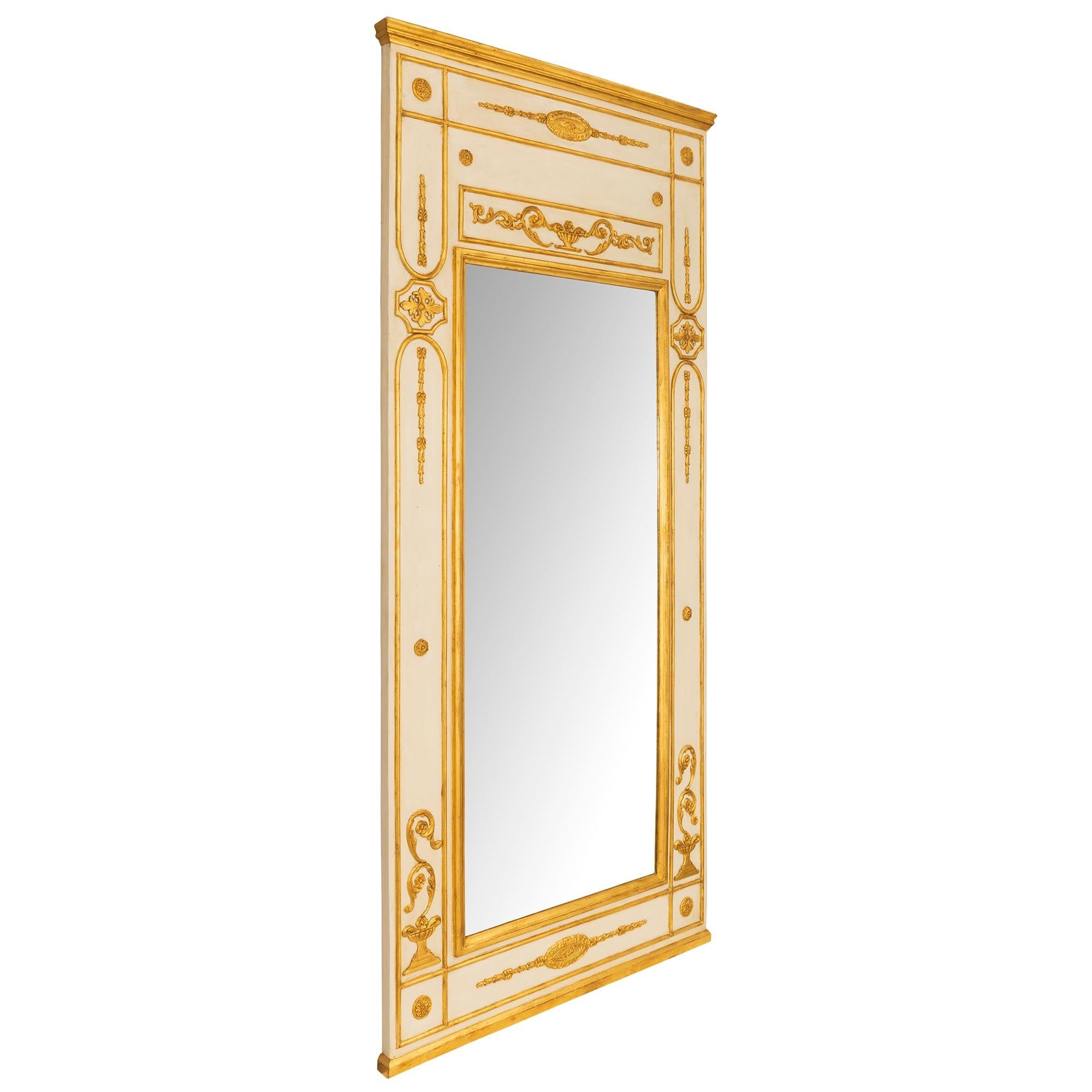 Impressionnante et très élégante paire de miroirs à trumeau en bois patiné et doré de style Louis XVI italien du XVIIIe siècle. Chaque miroir de grande taille conserve sa plaque d'origine, encadrée d'une fine bordure en bois doré tacheté. La base