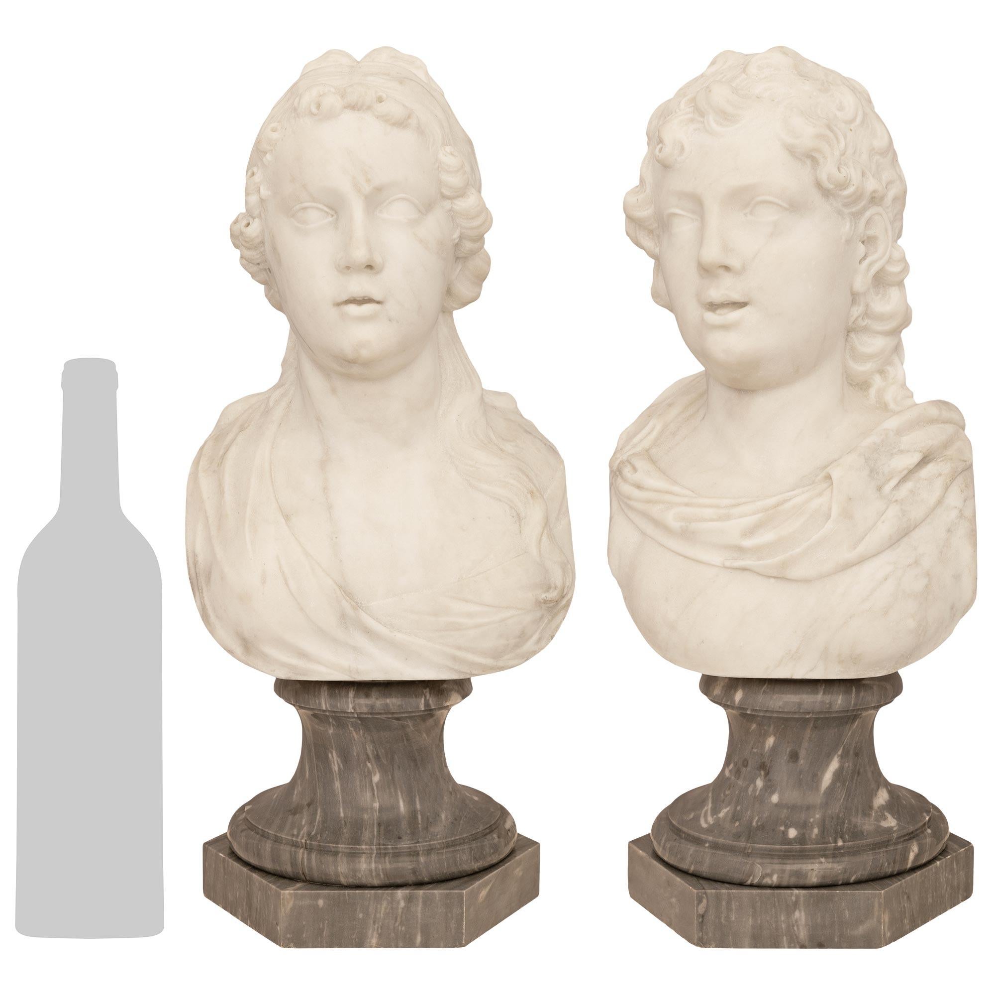 Elegante pareja de bustos italianos del siglo XVIII en mármol blanco de Carrara y gris de Santa Ana. Estos bustos romanos, finamente detallados, son de un niño y una niña, posiblemente hermano y hermana. Cada busto se eleva sobre una base hexagonal