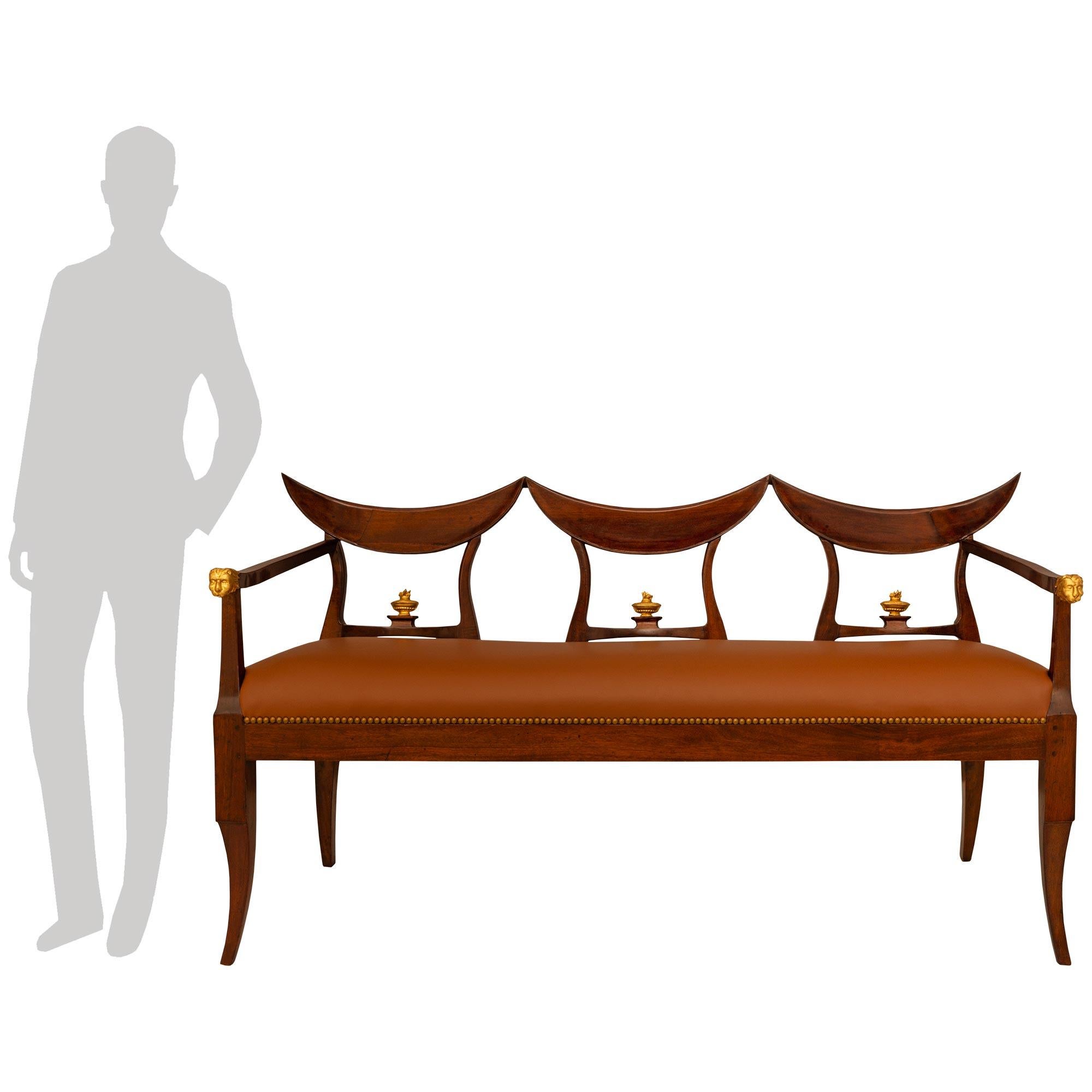 A handsome and unique pair of Italian 18th century Neo-Classical st. Walnut and Giltwood benches from Tuscany. Each three seat bench is raised by four square cabriole legs with the front legs displaying a lovely taper. The front legs lead into the