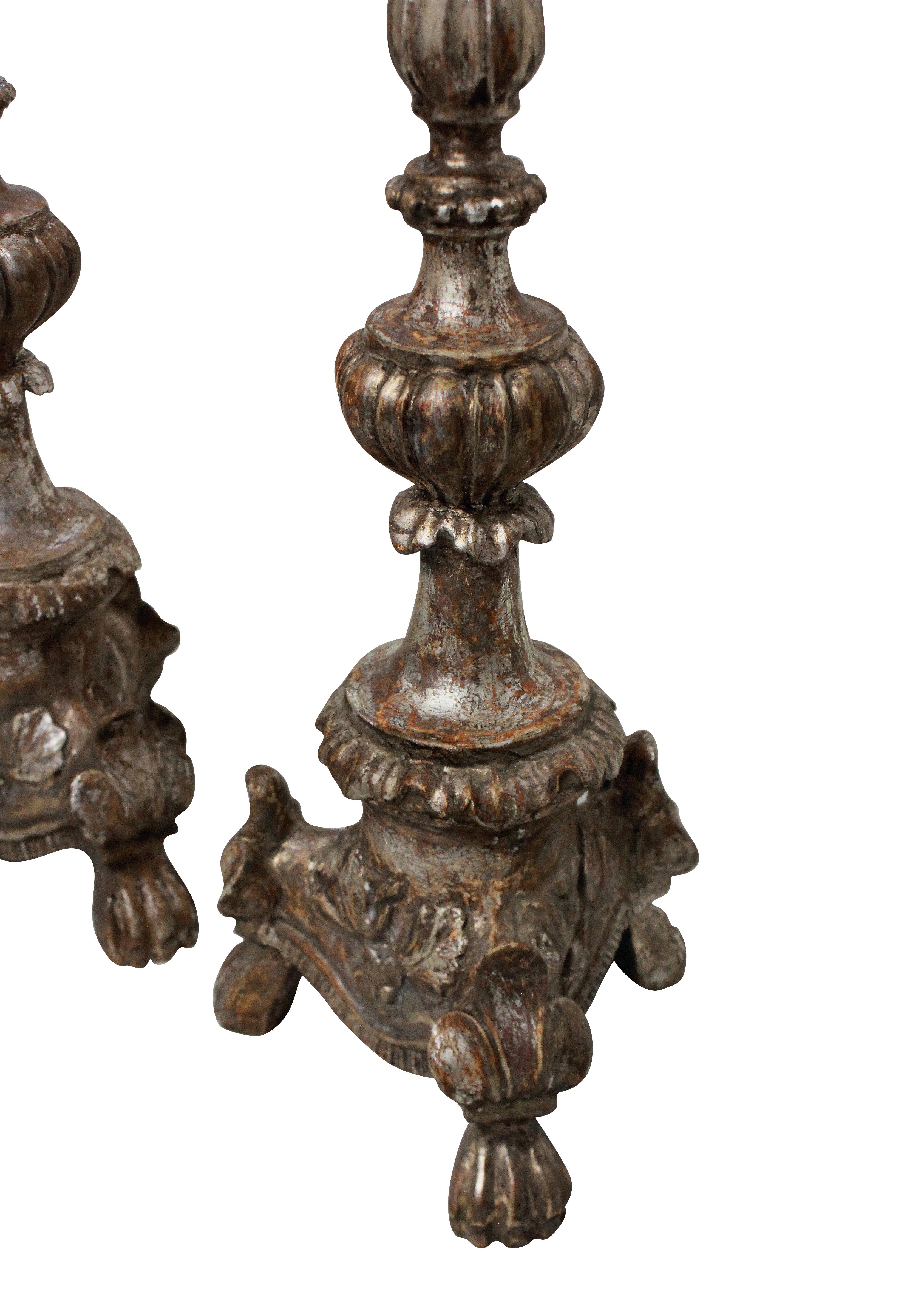 A pair of Italian 18th century, carved and silver leaf candlesticks as lamps.
  