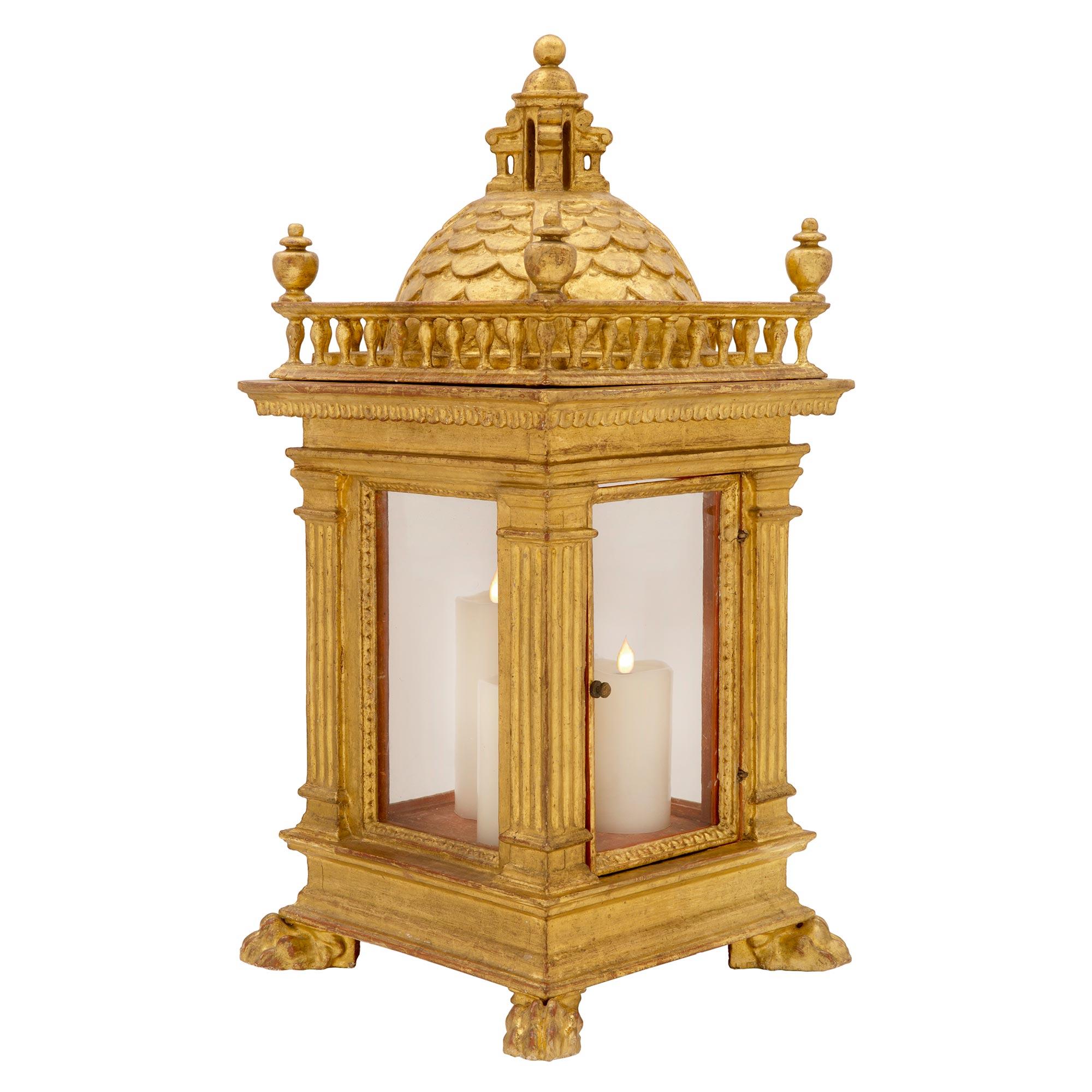 An exceptional and large scale pair of Italian 18th century Tuscan St. giltwood hurricane lanterns, circa 1750. Each lantern is raised by handsome richly carved paw feet below the square base with a decorative mottled design. Striking fluted