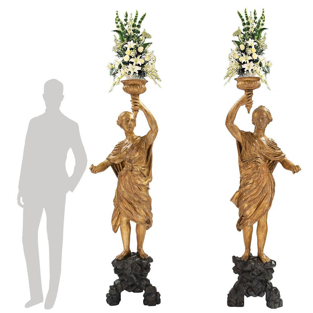A stunning true pair of Italian 18th century Venetian giltwood and polychrome torchières. Each impressive and life sized torchières raised by a wonderfully executed tripod base with a most decorative black polychrome rock design. Standing above are