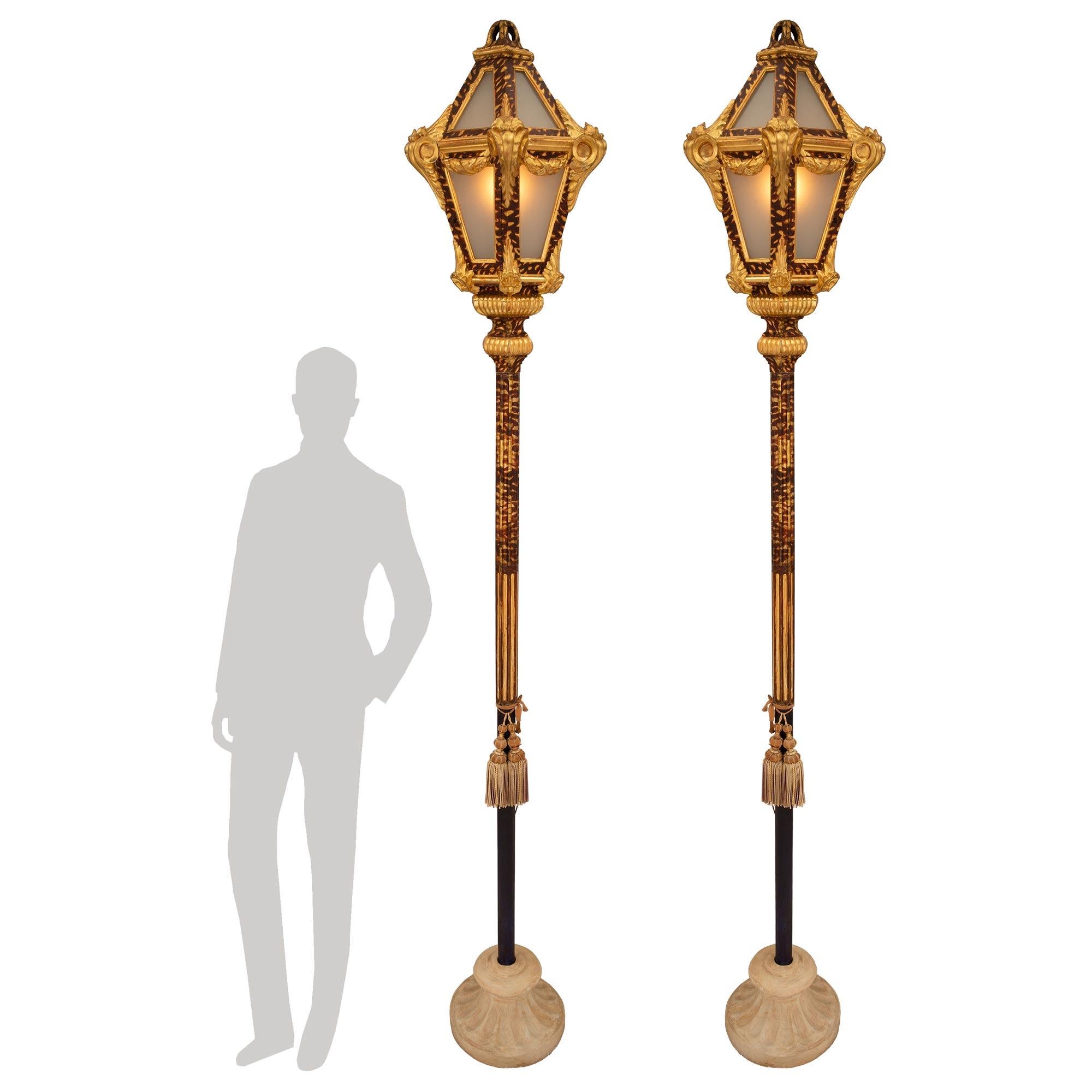 A most elegant pair of Italian 18th century Venetian st. patinated wood, faux tortoise shell and giltwood floor lamps. Each tall floor lamp is raised by a fine circular composite stone base with a lovely fluted design. The central wooden supports