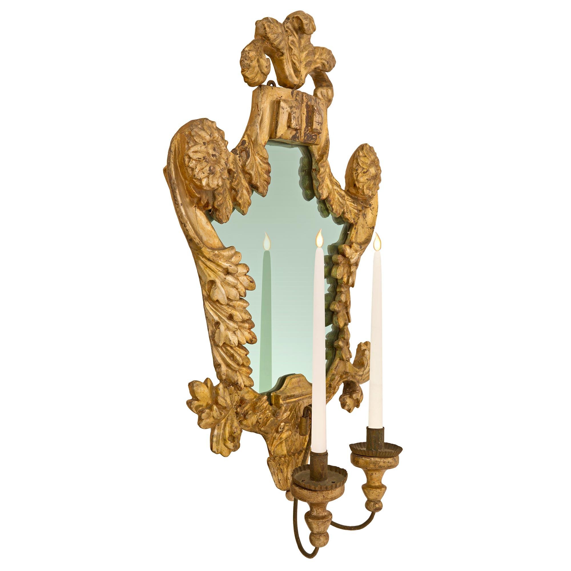 A stunning pair of Italian 18th century Venetian st. Mecca and wrought iron mirrored sconces. Each beautifully shaped sconce retains its original mirror plate set within most decorative scrolled carved foliate designs and richly carved leaves