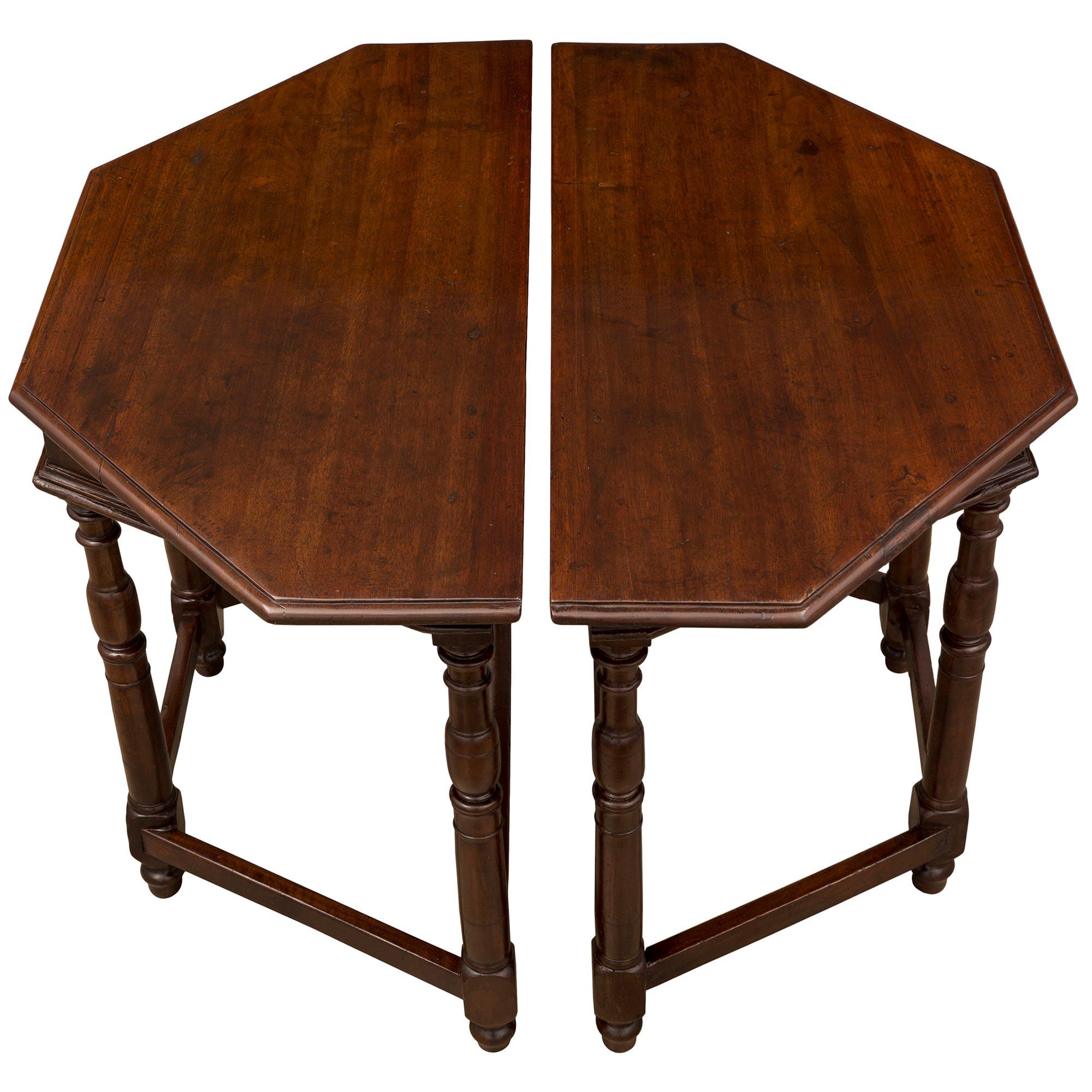 A handsome pair of Italian 18th century walnut consoles/center table from Tuscany. Each console is raised by elegant mottled topie shaped feet below circular baluster legs each connected by straight stretchers. The straight aprons display fine