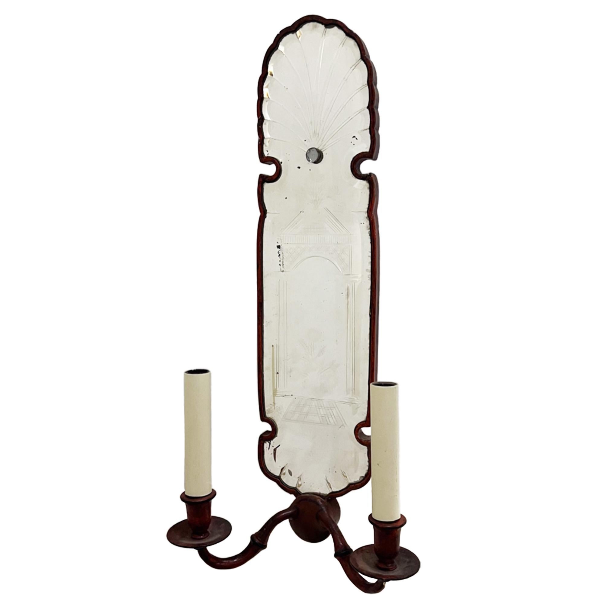 This pair of decorative wall lights was made in Italy in the 1920s. 

The tall, narrow backplates have arched tops with a scalloped edge. The original pieces of glass have an etched pattern, incorporating a neoclassical building and a fan motif at