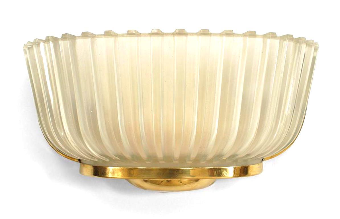 Pair of Italian 1940s moulded frosted glass wall sconces with fluted design and half round shape supported in a brass frame, attributed: Barovier e Toso.


Barovier e Toso is a renowned Venetian company creating solutions of decorative lighting in