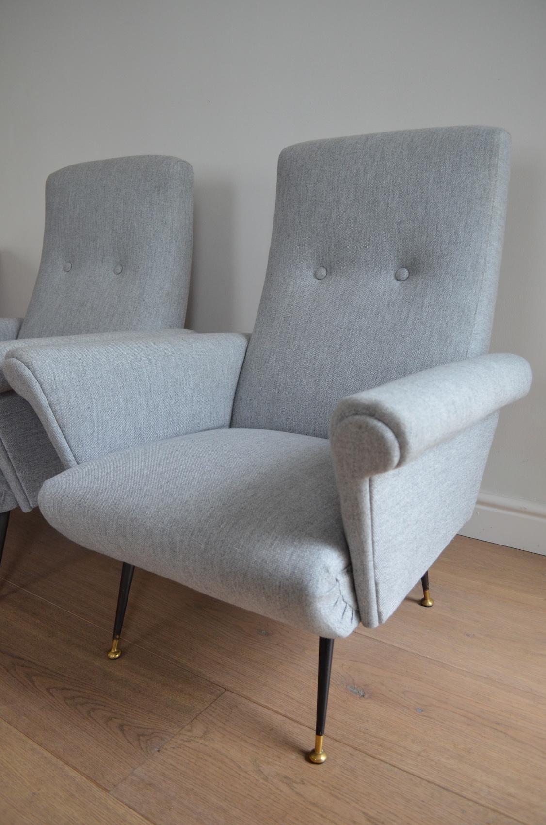 A pair of armchairs produced in Italy in the late 1950s.

The bold style is a quintessential example of the originality and dare of the era’s Italian design.

Standing on black enameled tapered legs and brass feet with later reupholstery.