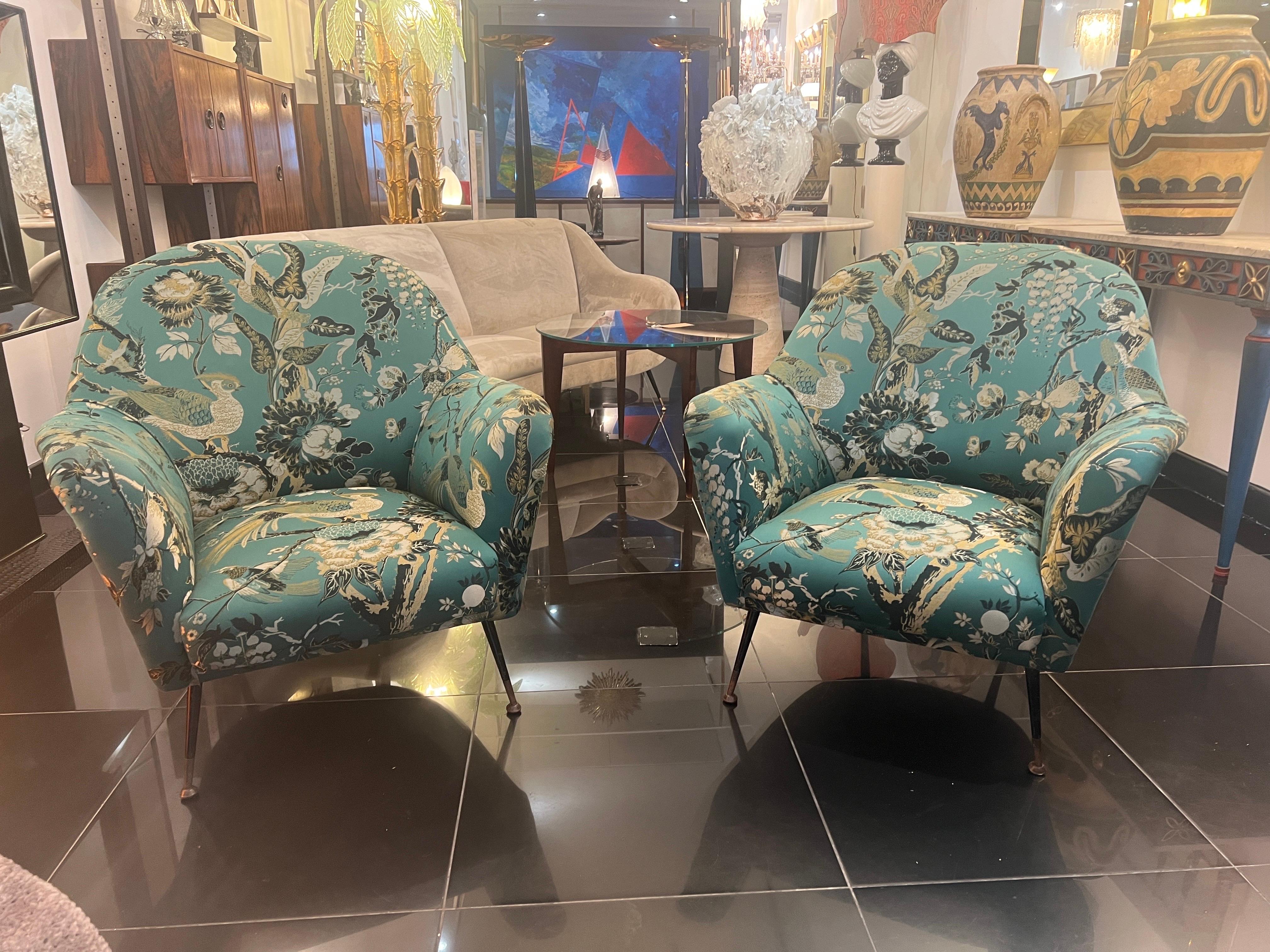 A fine pair of Italian 1950s armchairs beautifully upholstered in botanical birds silk fabric with raised embroidery. Spectacular design and details. The armchairs are supported by four conical legs in black enamelled steel with brass sabots. 