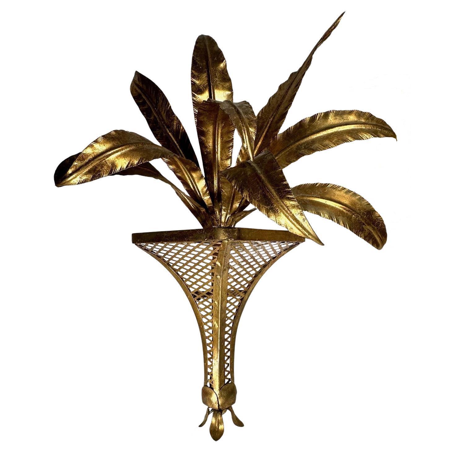 Pair of Italian 1950s Hollywood Regency Gilt Tole Palm Motif Wall Sconces

Mid-century vintage Hollywood Regency Florentine gilt iron and tole Palm wall sconces. This decorative pair of Italian wall lights with gilded metal palm leaves is mounted on
