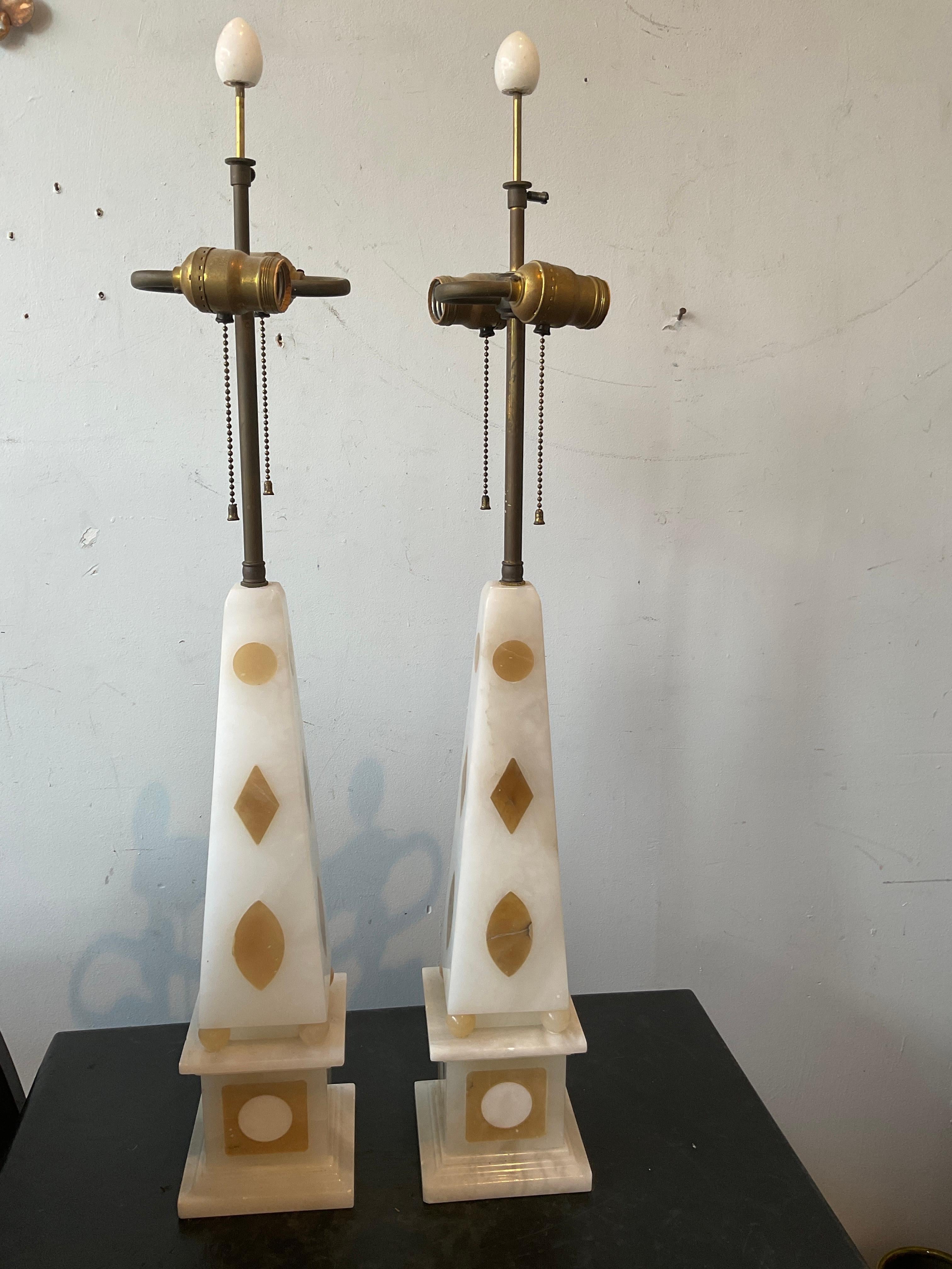 Pair of 1950s inlaid marble obelisk lamps . Height  is to top of socket. Scratch on the back of one lamp as shown in last image.
Lamps need rewiring.