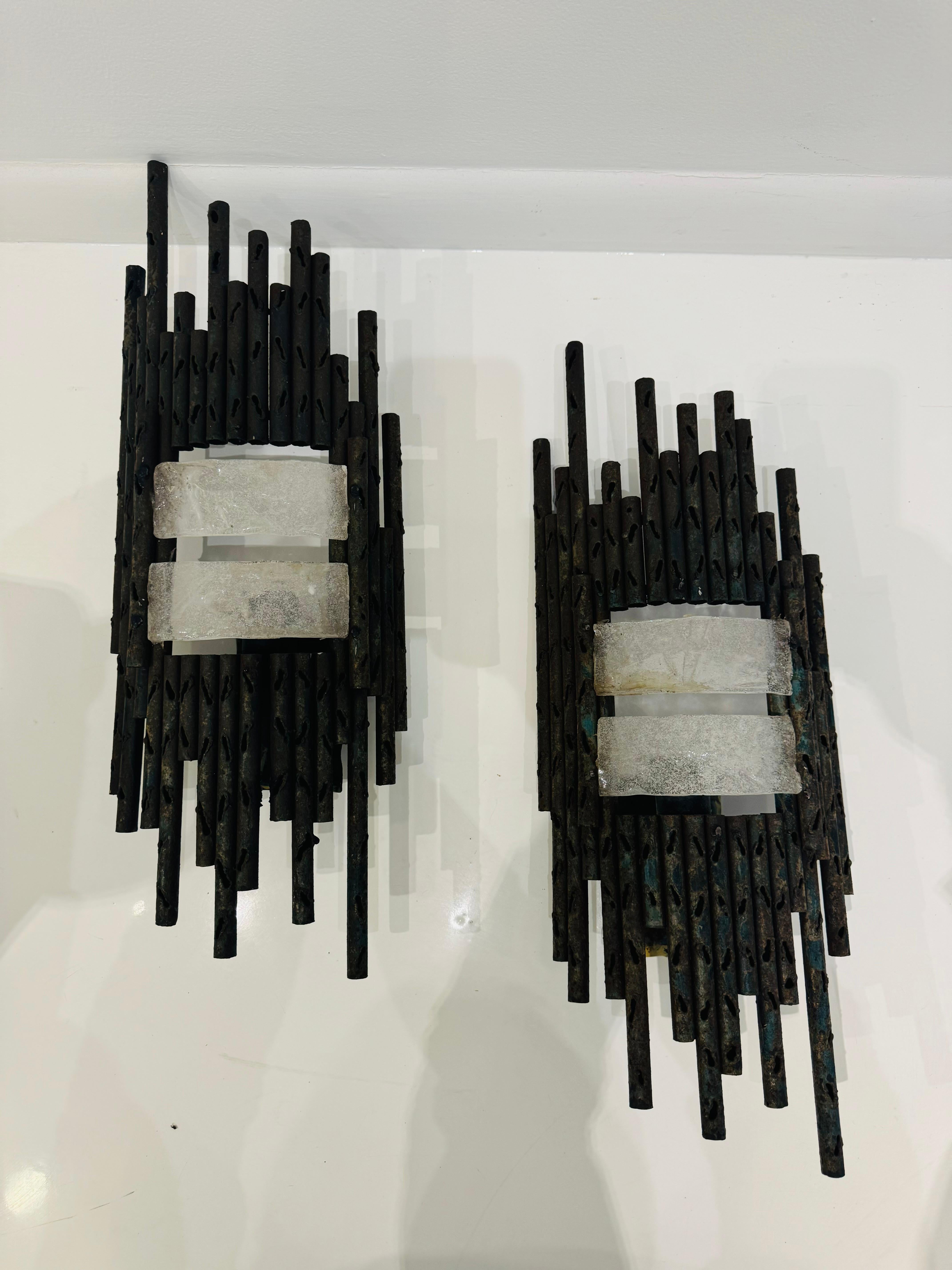 A wonderful large pair of aged pierced iron and bubble clear ribbon glass wall lamps by the Italian artist, M. Fantoni. Rewired with a large standard socket.