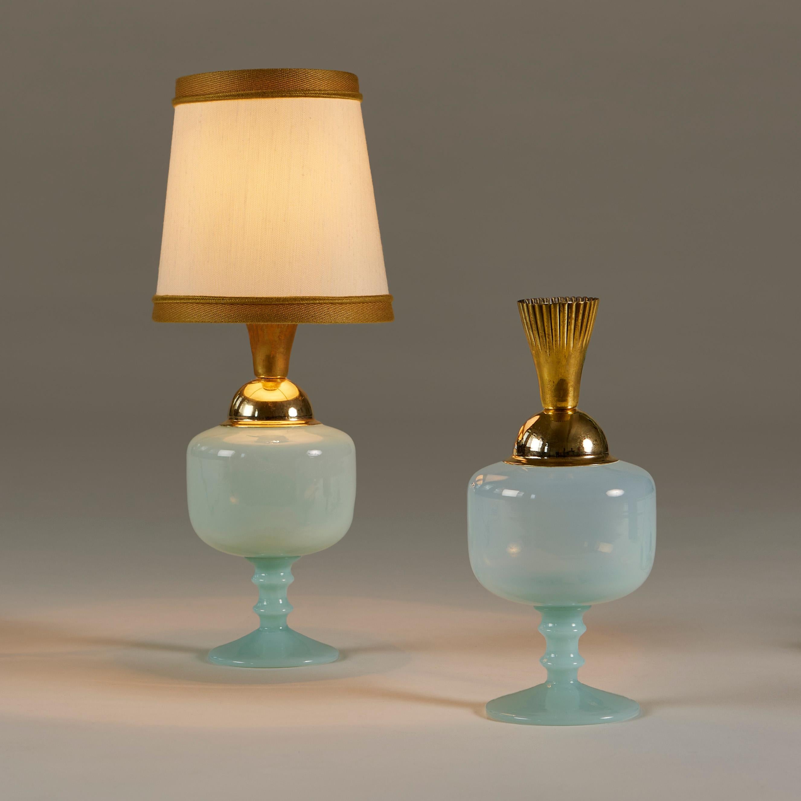 Pale turquoise glass table urn shaped lamps with decorative brass fittings. Perfect for a dressing-table or desk or anywhere in need of a mood enhancing touch.

