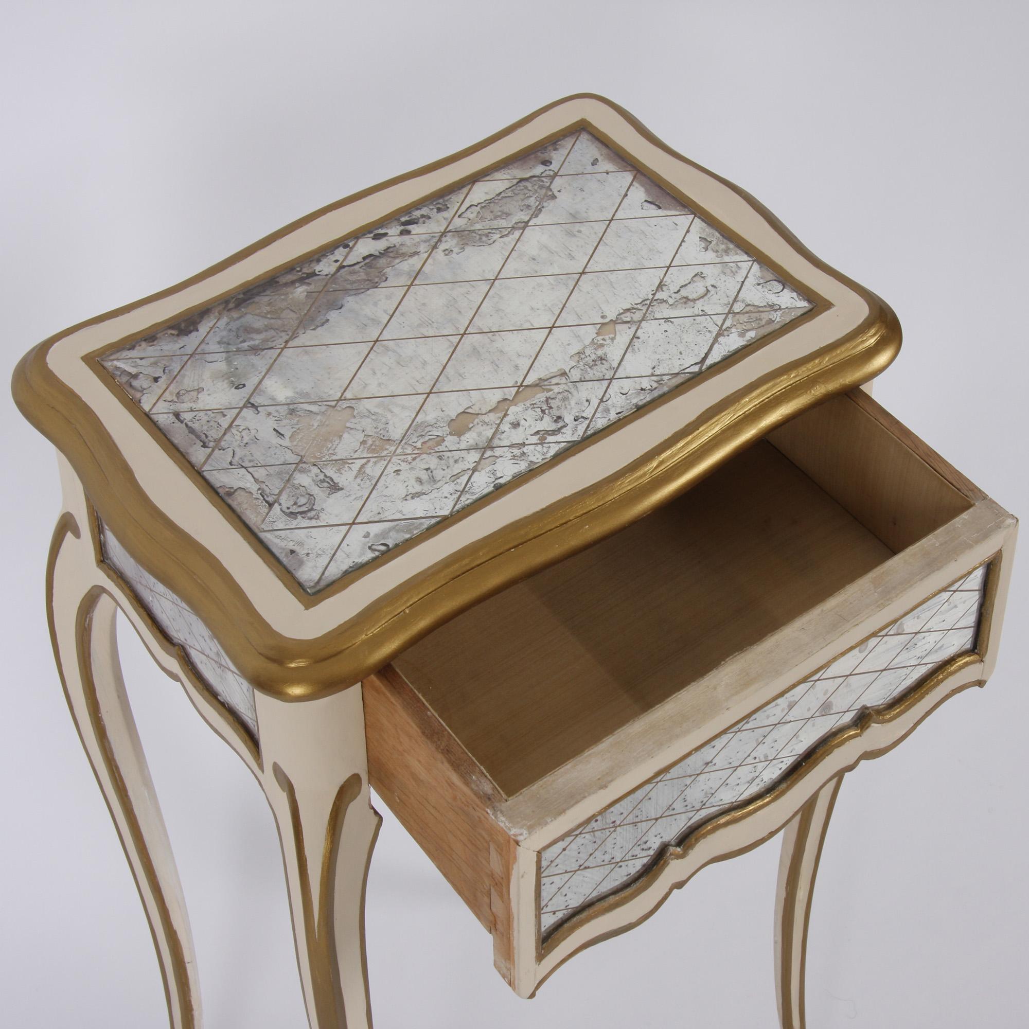 This elegant pair of painted and gilt side tables, with original Verre Églomisé mirror drawers, date back to 1950s Italy.