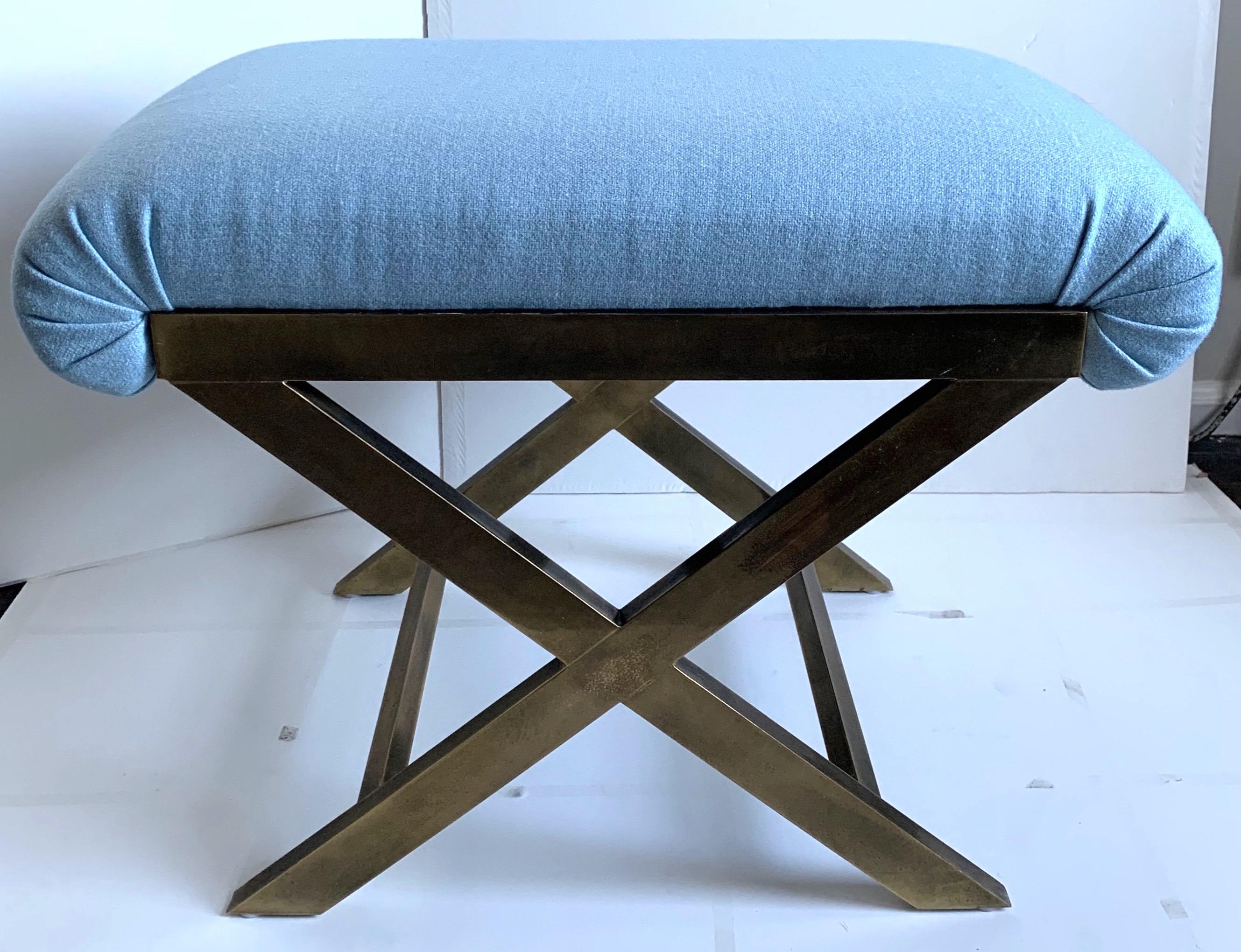 Pair of 1970s Italian brass X-benches. Overall burnished unpolished solid brass X-base frame. Newly upholstered in Raoul textiles ice blue (light blue) wool fabric. Each bench retains “Made in Italy” sticker.