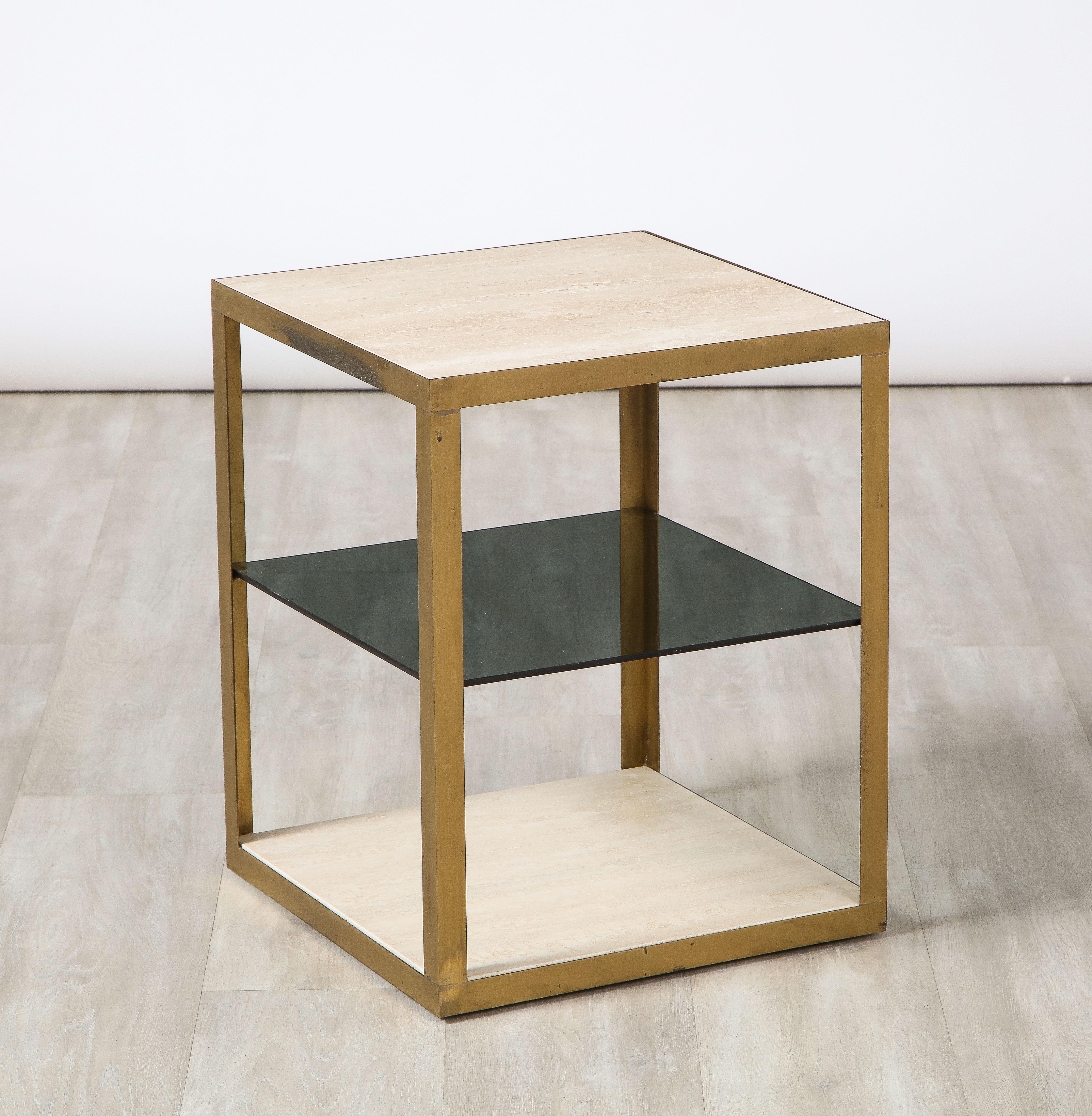 A pair of Italian 1970's square side tables, the inset travertine top and lower base in travertine and the mid-section shelf in smoked glass; the whole with brass trim and supports. A glamourous addition to any interior. Extremely well made and