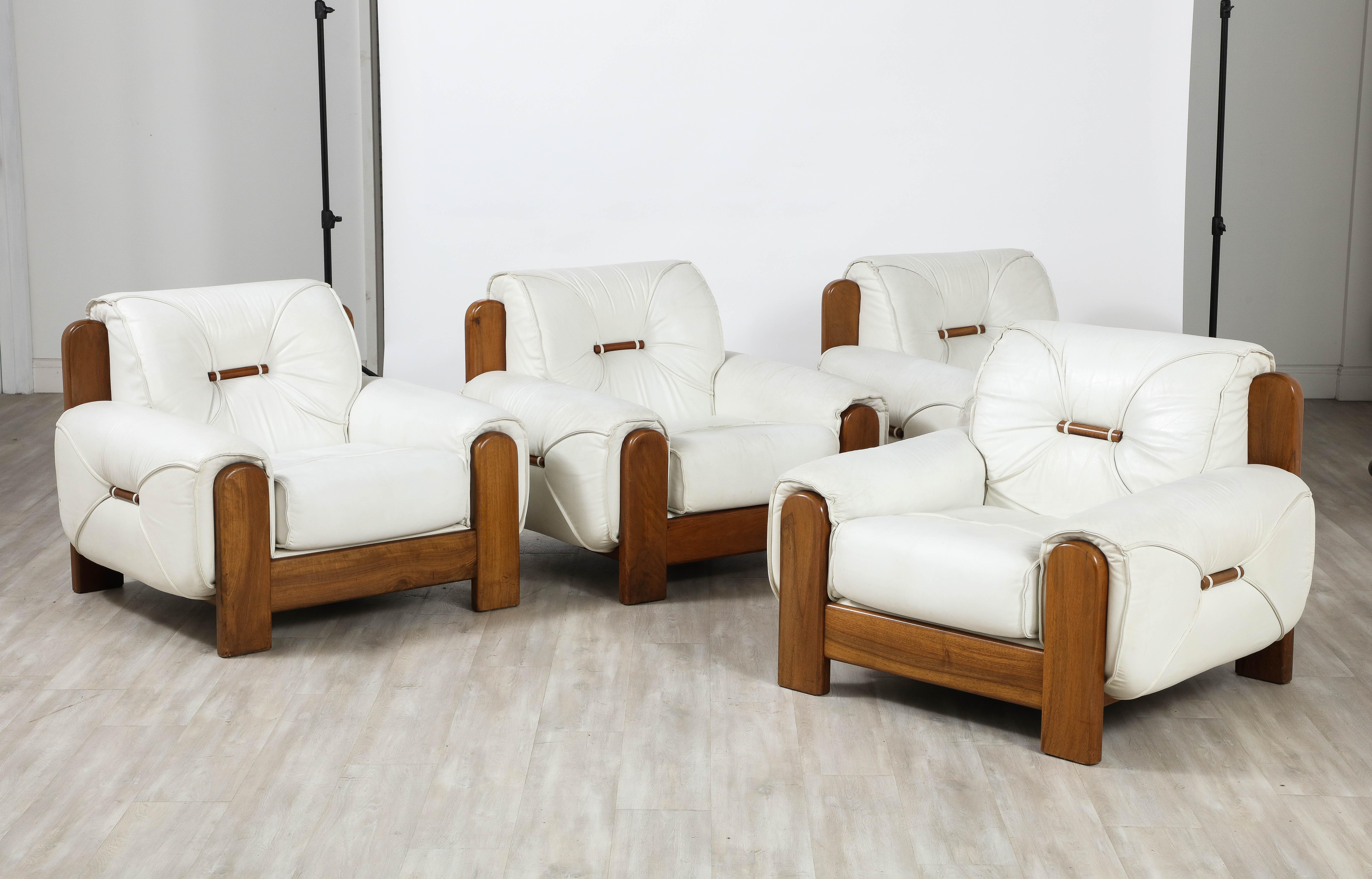 A highly unique and superb pair of Italian 1970's lounge chairs. Hand-crafted with a nod toward the Brazilian iconic designers of the period, Jean Gillon and Sergio Rodrigues. The robust walnut frames are a stunning contrast to the original white